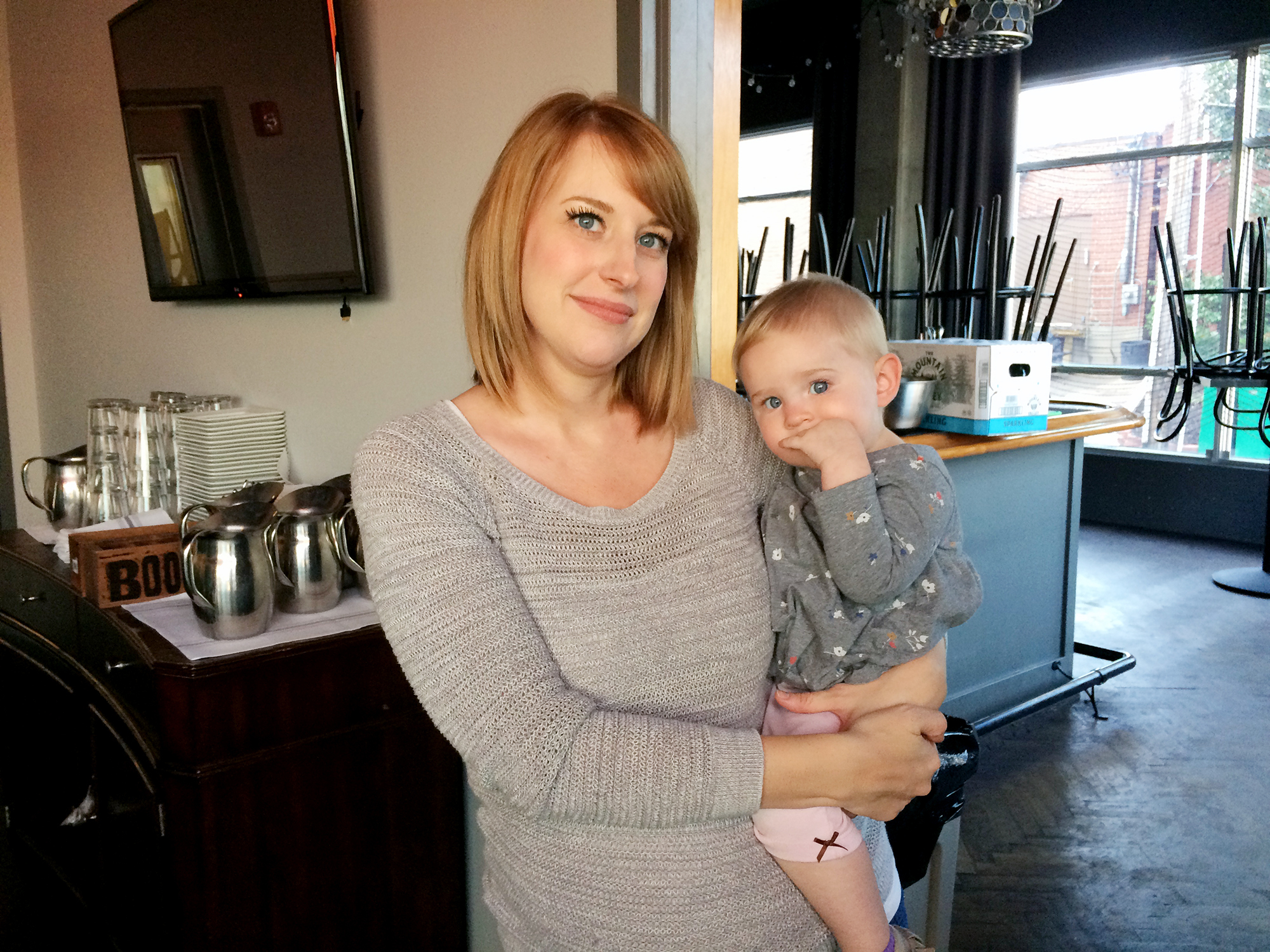 Keely Edgington and her daughter, Lula, pose inside their family-owned restaurant, Julep, in Kansas City, Mo. Lula was diagnosed with a neuroblastoma when she was 9 months old. She's now 16 months old. (Alex Smith / KCUR)
