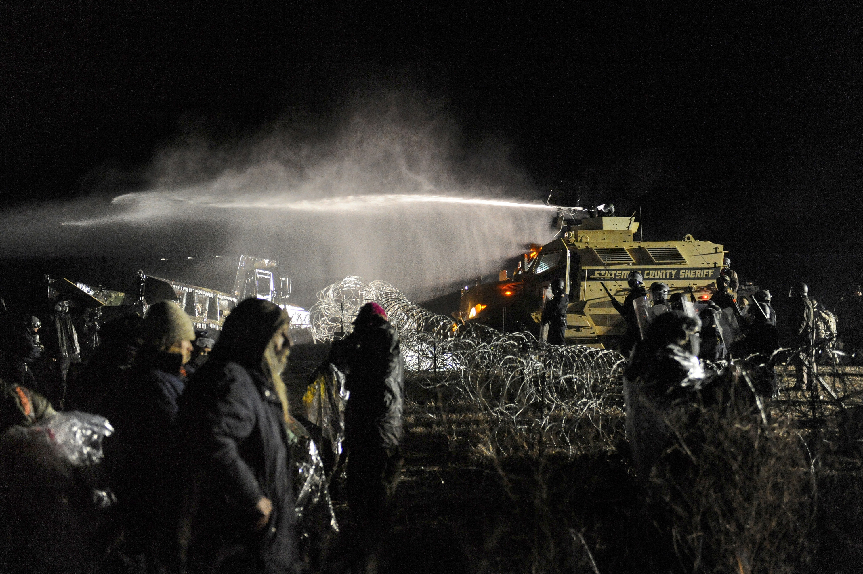 Police use a water canon to spray protesters during a clash overnight near Cannon Ball., N.D. (Reuters)