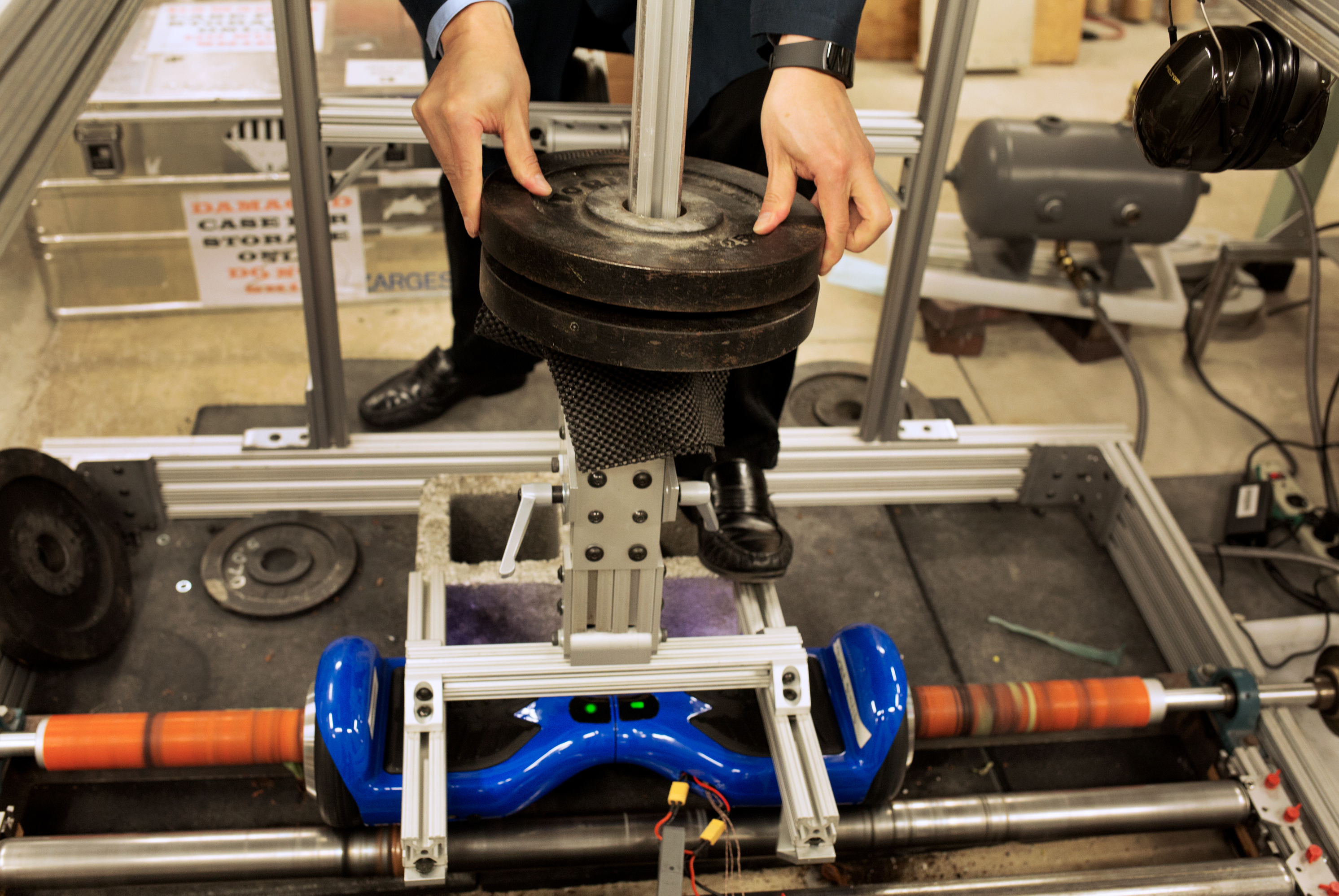 Electrical engineer Doug Lee adds weights to the setup the lab built to test hoverboards.
