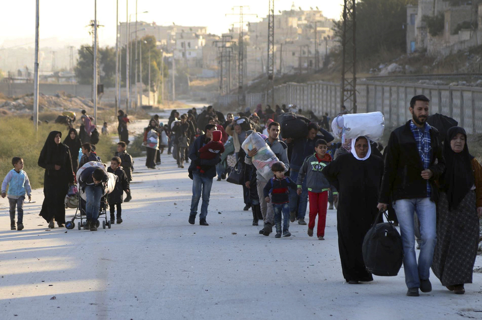 People flee rebel-held eastern neighborhoods of Aleppo into the Sheikh Maqsud area, controlled by Kurdish fighters, in Syria on Sunday. The photo was provided by the Rumaf, a Syrian Kurdish activist group, and authenticated by The Associated Press. (The Rumaf/AP)