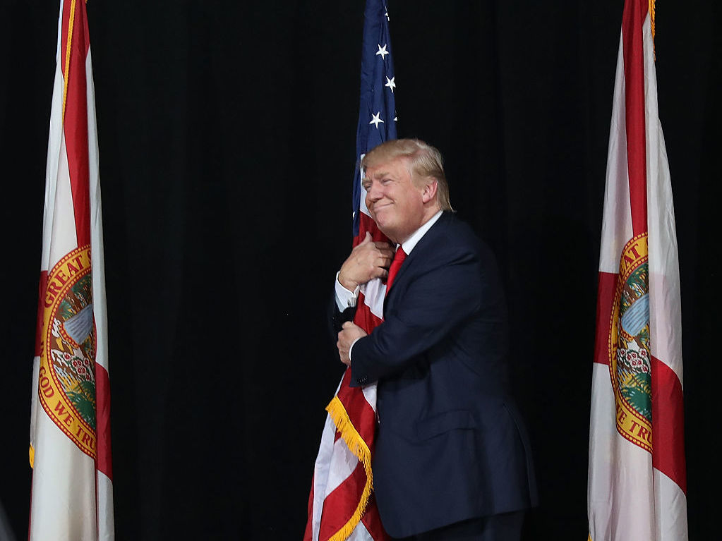 Donald Trump hugs the American flag at a campaign rally in Tampa, Fla., on Oct. 24. (Getty Images)