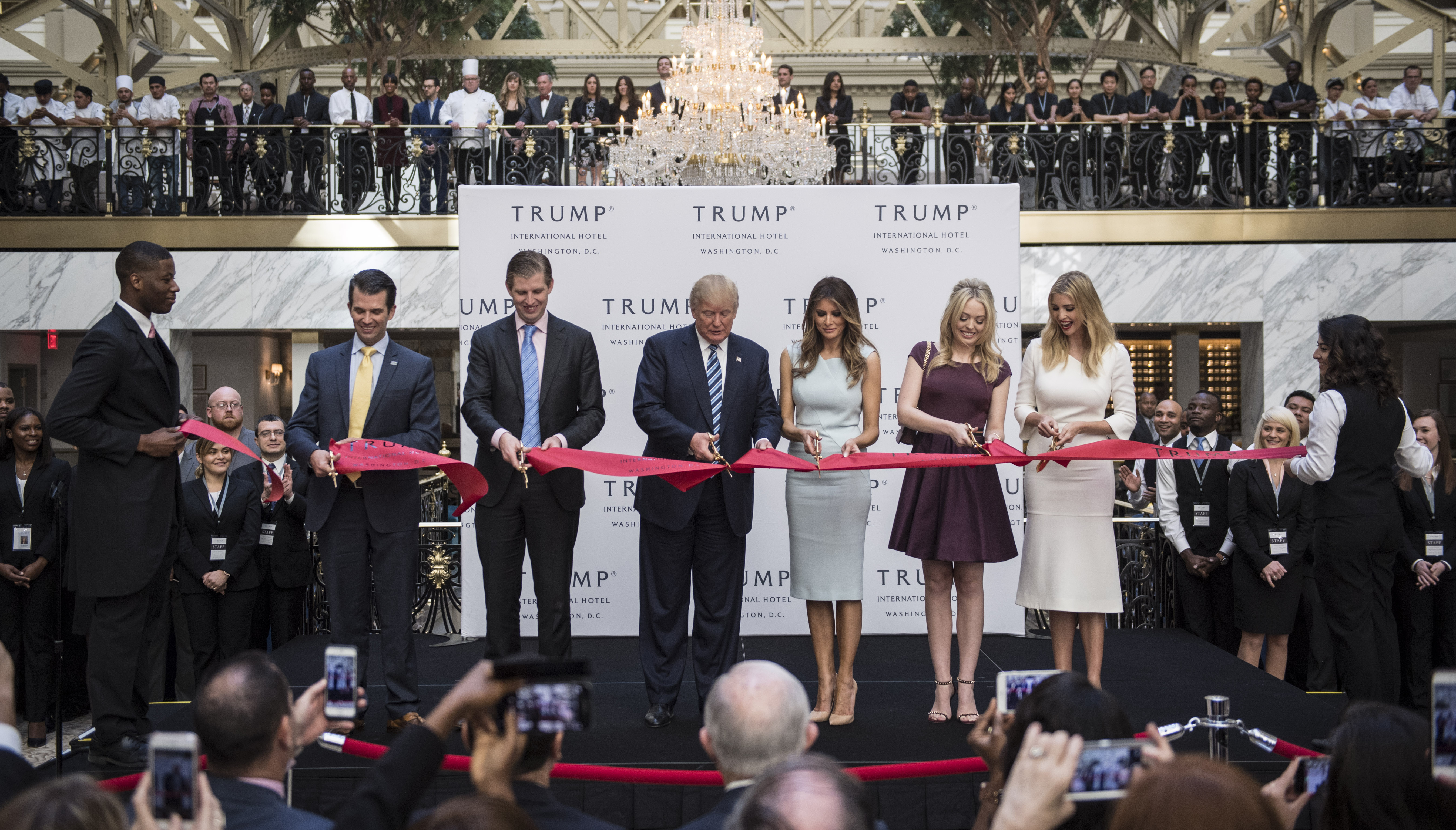 President-elect Donald Trump, flanked by his wife and grown children, cuts a ribbon during the grand opening of the Trump International Hotel, just a few blocks from the White House, on Oct. 26. (Getty Images)