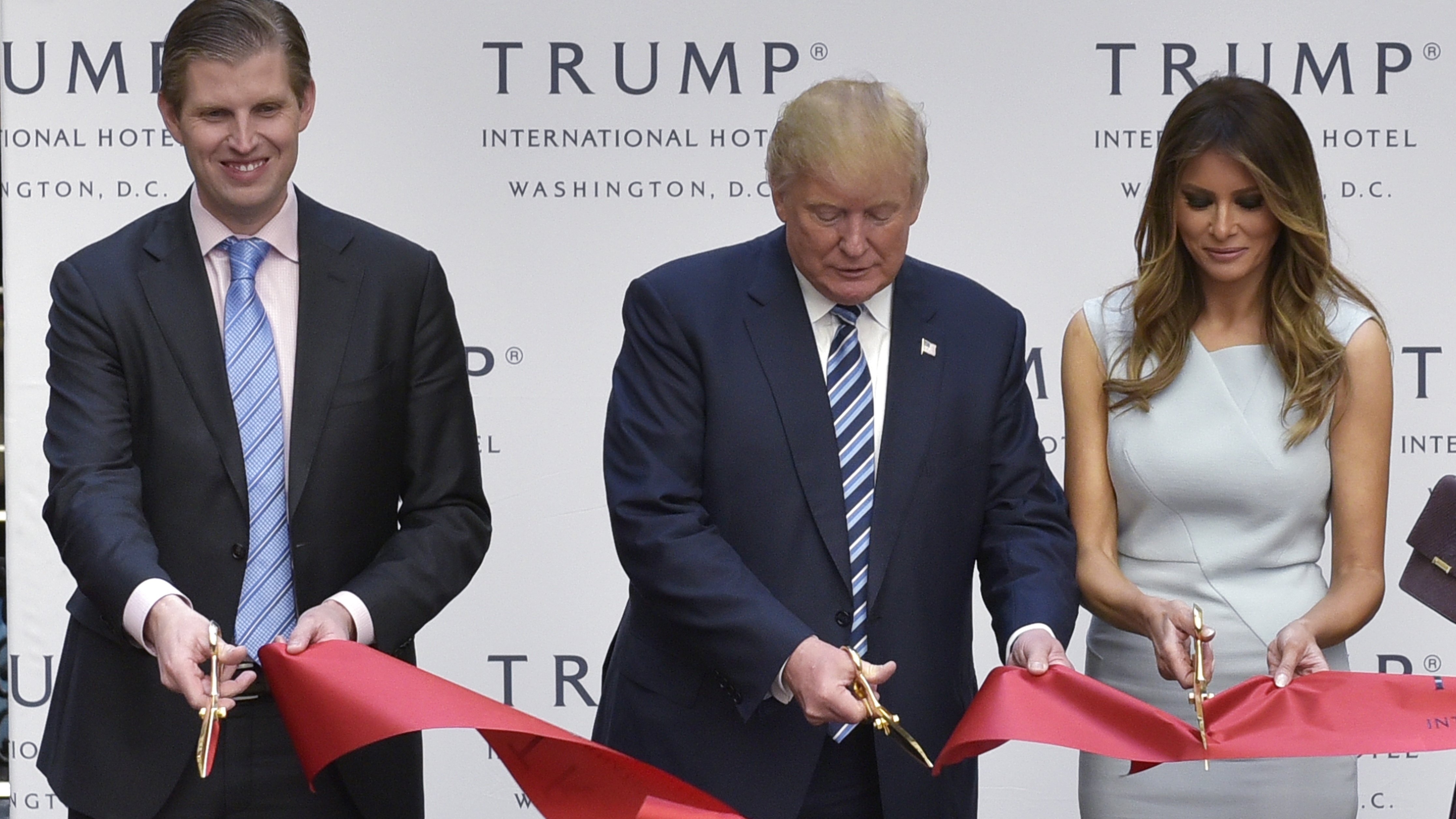 Donald Trump, along with his wife, Melania, and son Eric, cuts the ribbon during the grand opening ceremony for the Trump International Hotel, located in the Old Post Office building in Washington, D.C. The building, which is owned by the General Services Administration, is leased to the Trump family. (AFP/Getty Images)