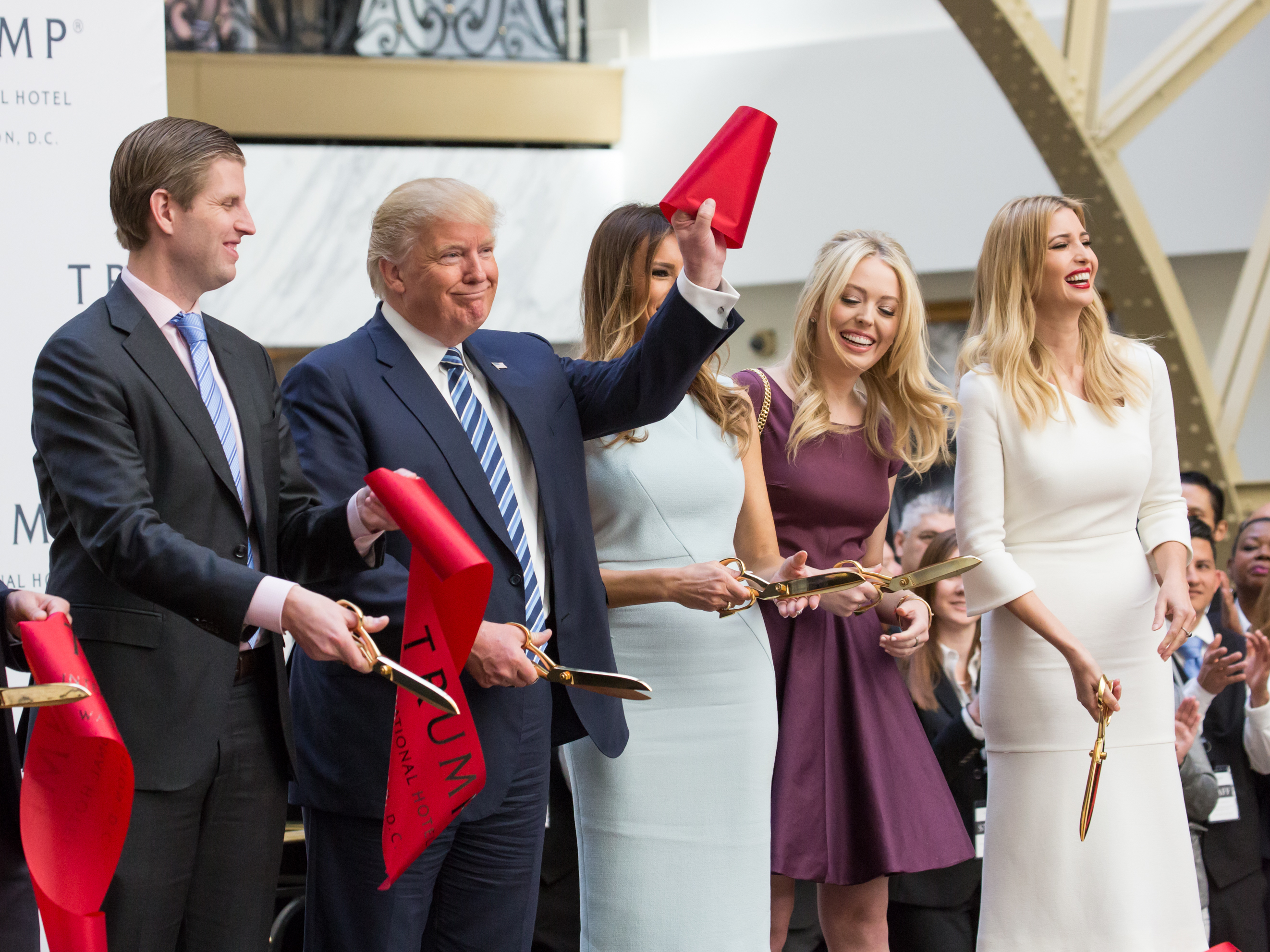 Standing with his son Eric, wife Melania, and daughters Tiffany and Ivanka, Donald J. Trump cuts the ribbon for his latest property, the Trump International Hotel in Washington, D.C., on Oct. 26. (NurPhoto via Getty Images)