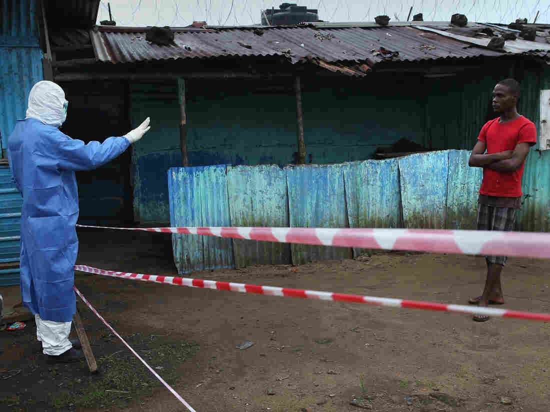 A doctor keeps a pedestrian away from the JFK Ebola treatment center on October 13, 2014 in Monrovia, Liberia. (Photo by John Moore/Getty Images)
