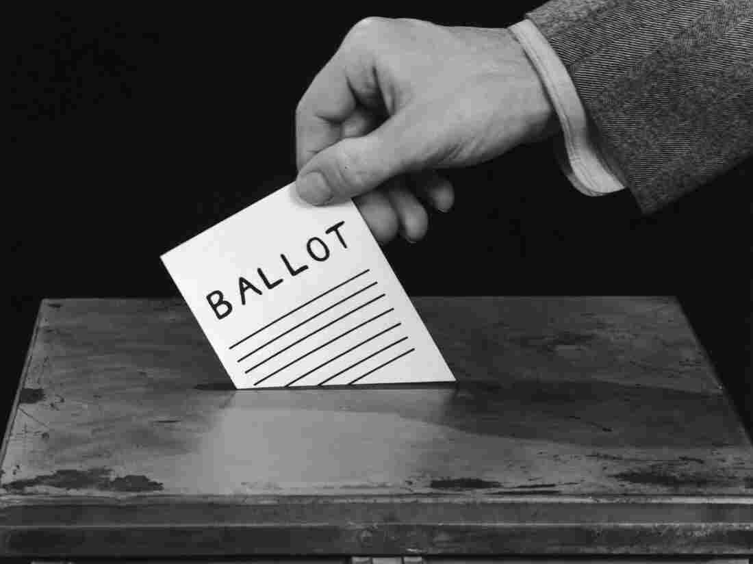 circa 1955: Closeup of a man's hand preparing to drop a ballot through the slot of a padlocked ballot box. (Photo by Harold M. Lambert/Lambert/Getty Images)