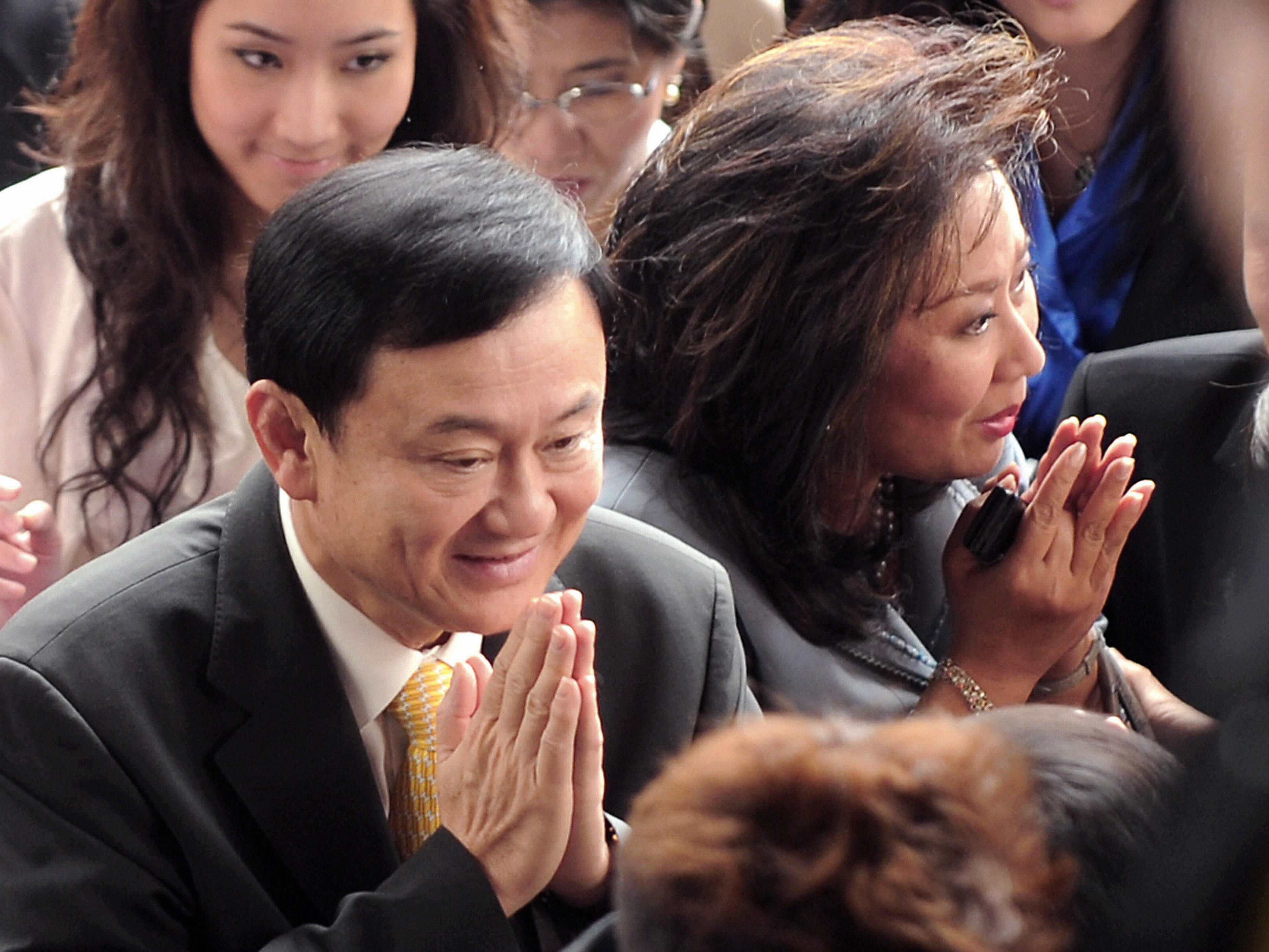 Thailand's deposed prime minister, Thaksin Shinawatra (left), and his wife, Pojaman, greet supporters on arrival at a court in Bangkok in July 2008. He was convicted on conflict of interest charges and lives in self-imposed exile.