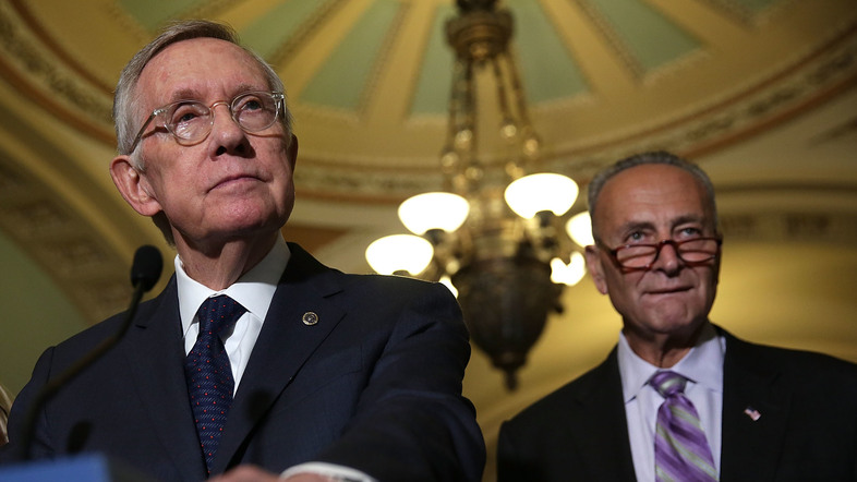 U.S. Senate Minority Leader Harry Reid, D-Nev., speaks to members of the media Sept. 9 at the Capitol. Reid is retiring after this Congress; he'll be succeeded as minority leader by Sen. Charles Schumer, D-N.Y. (right). (Alex Wong/Getty Images)