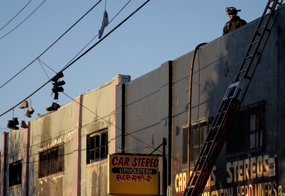 On Saturday, firefighters investigate the scene of the overnight fire at the Ghost Ship warehouse in the Fruitvale neighborhood of Oakland. (Elijah Nouvelage/Getty Images)