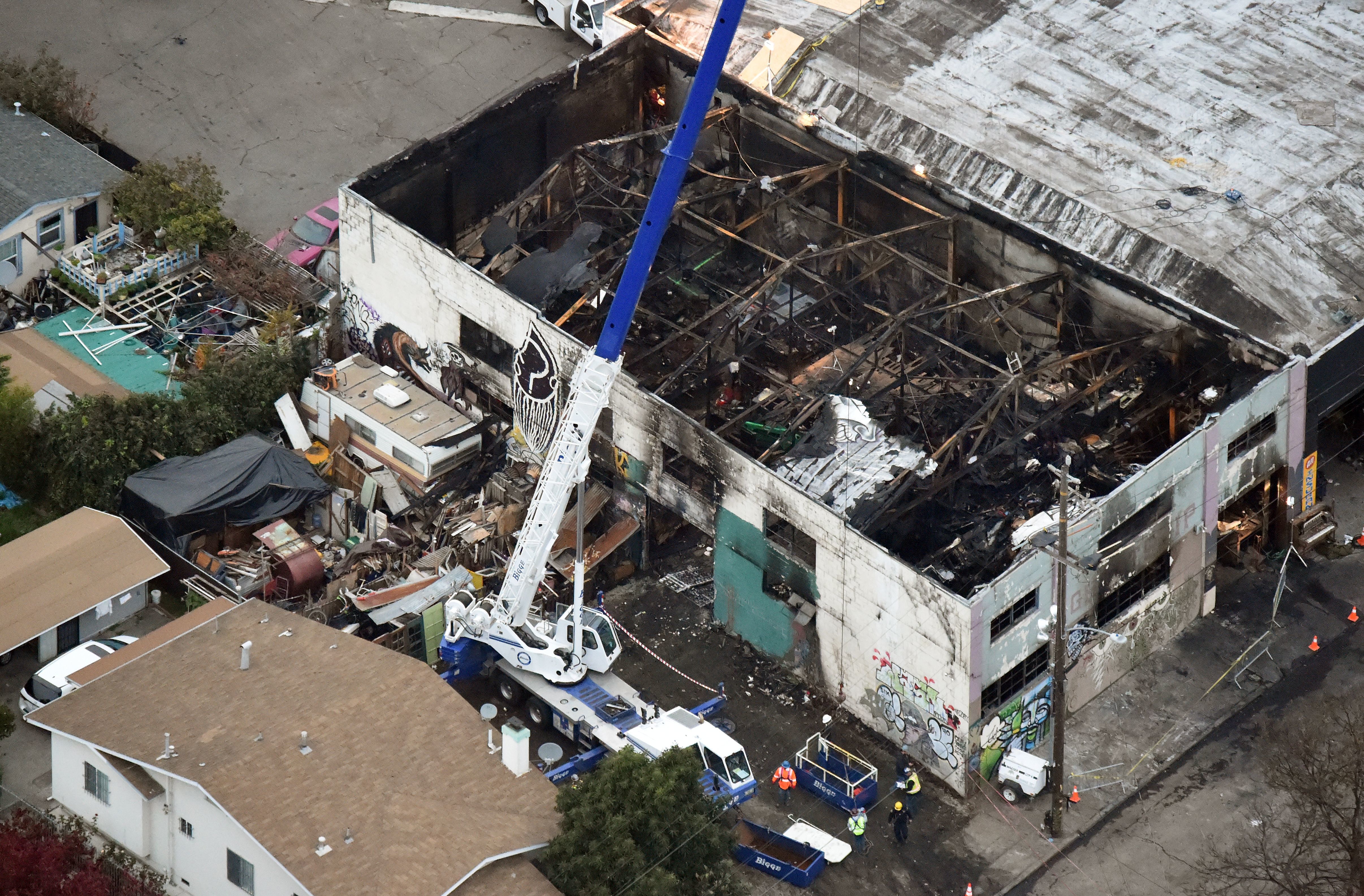 A crane is used to lift wreckage on Monday as part of search efforts in a fire-ravaged warehouse in Oakland, California. The death toll from the massive weekend fire at an artists' collective stands at 36, authorities say. (AFP/Getty Images)