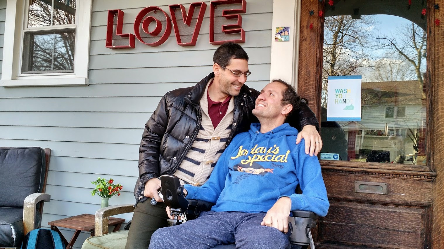 Dave Adox, right, and his husband Danni Michaeli at their home in South Orange, N.J., in the fall of 2014. Adox was diagnosed with ALS at age 42 and became almost totally paralyzed within six months. He died last May. (Courtesy of Evan Bachner)