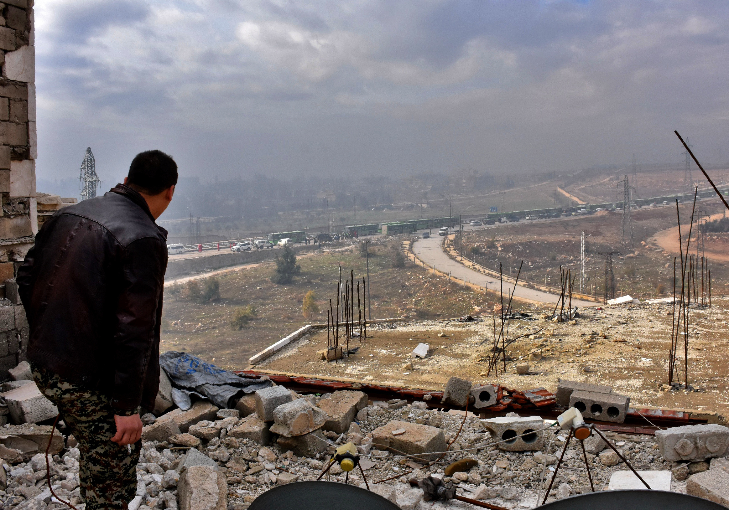A member of the Syrian government forces watches during an evacuation of Syrian rebel fighters and civilians from a opposition-held area of Aleppo on Friday. (AFP/Getty Images)