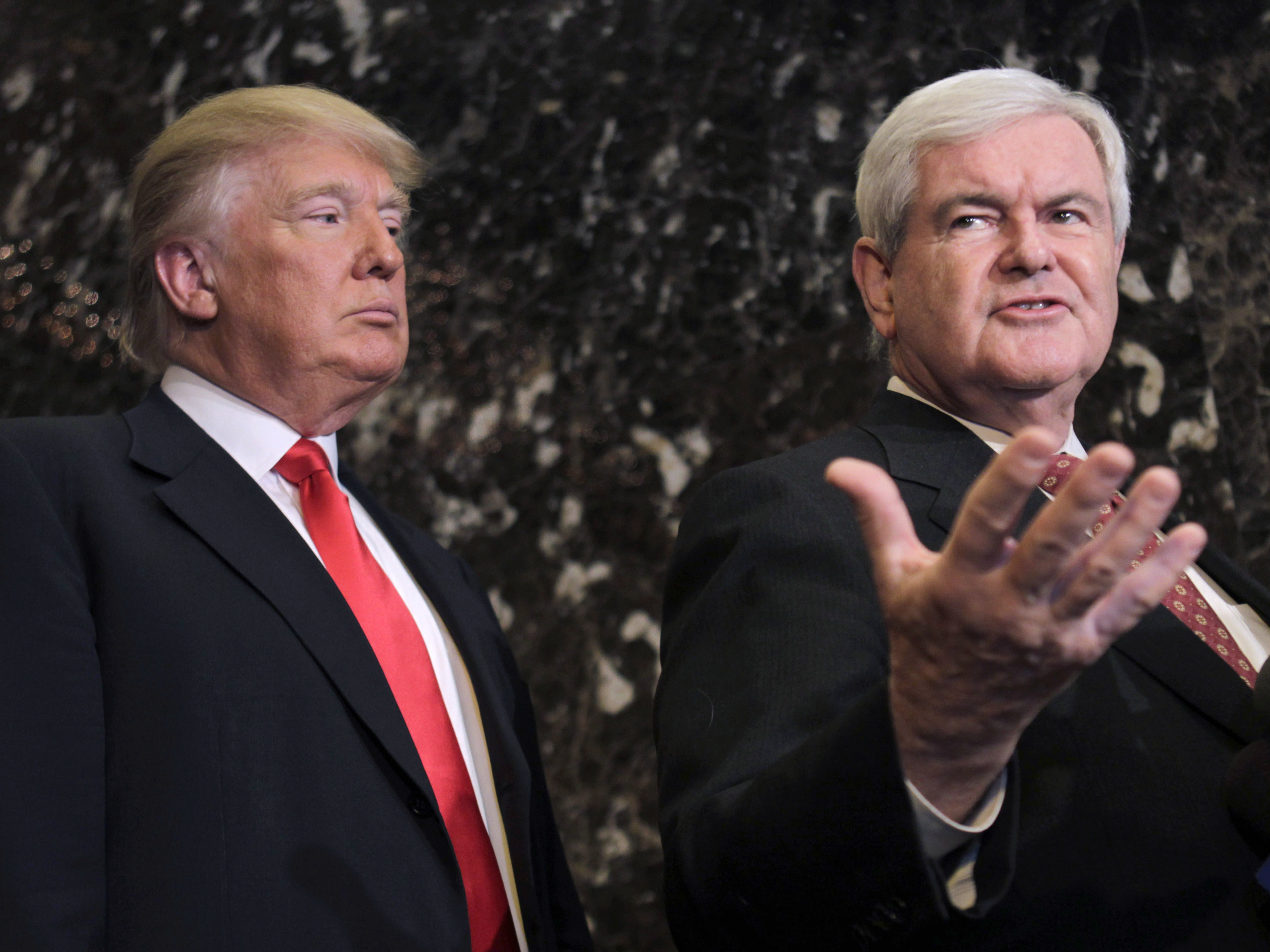 President-elect Donald Trump listens as former House Speaker Newt Gingrich talks to reporters in New York City on Dec. 5. Gingrich suggests that a panel of experts monitor Trump's business conflicts after he takes office.