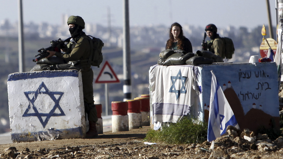 The U.N. Security Council has condemned Israel's construction of settlements, with Ambassador Samantha Power saying the project hurts Israel's security. In this photo from March, soldiers guard the Gush Etzion junction near a cluster of settlements in the West Bank. (Mahmoud Illean/AP)