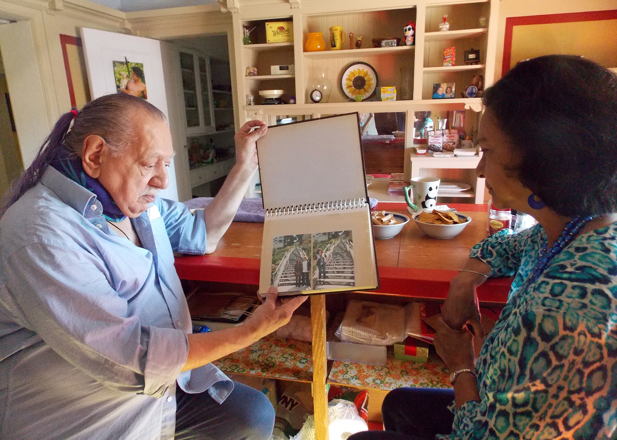 Emil Girardi, 83, and Shipra Narruhn, 67, chat in Girardi's San Francisco apartment. They were paired through a nonprofit called Little Brothers, Friends of the Elderly, which aims to relieve isolation and loneliness.