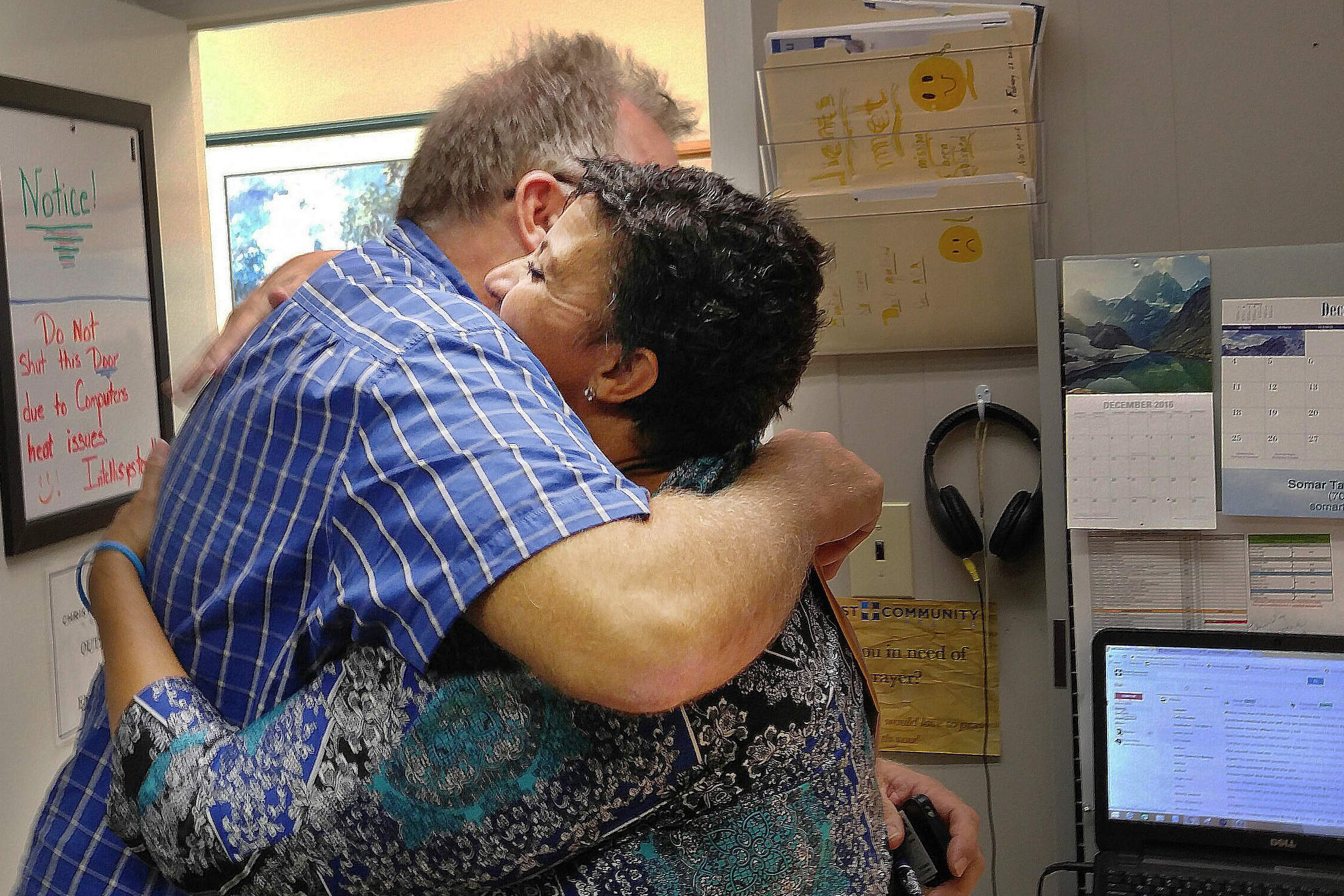 Ron Ellis of Augusta, Ga., hugs Monica Baldwin, a navigator with Christ Community Health, after she helped him sign up for insurance through the Affordable Care Act.