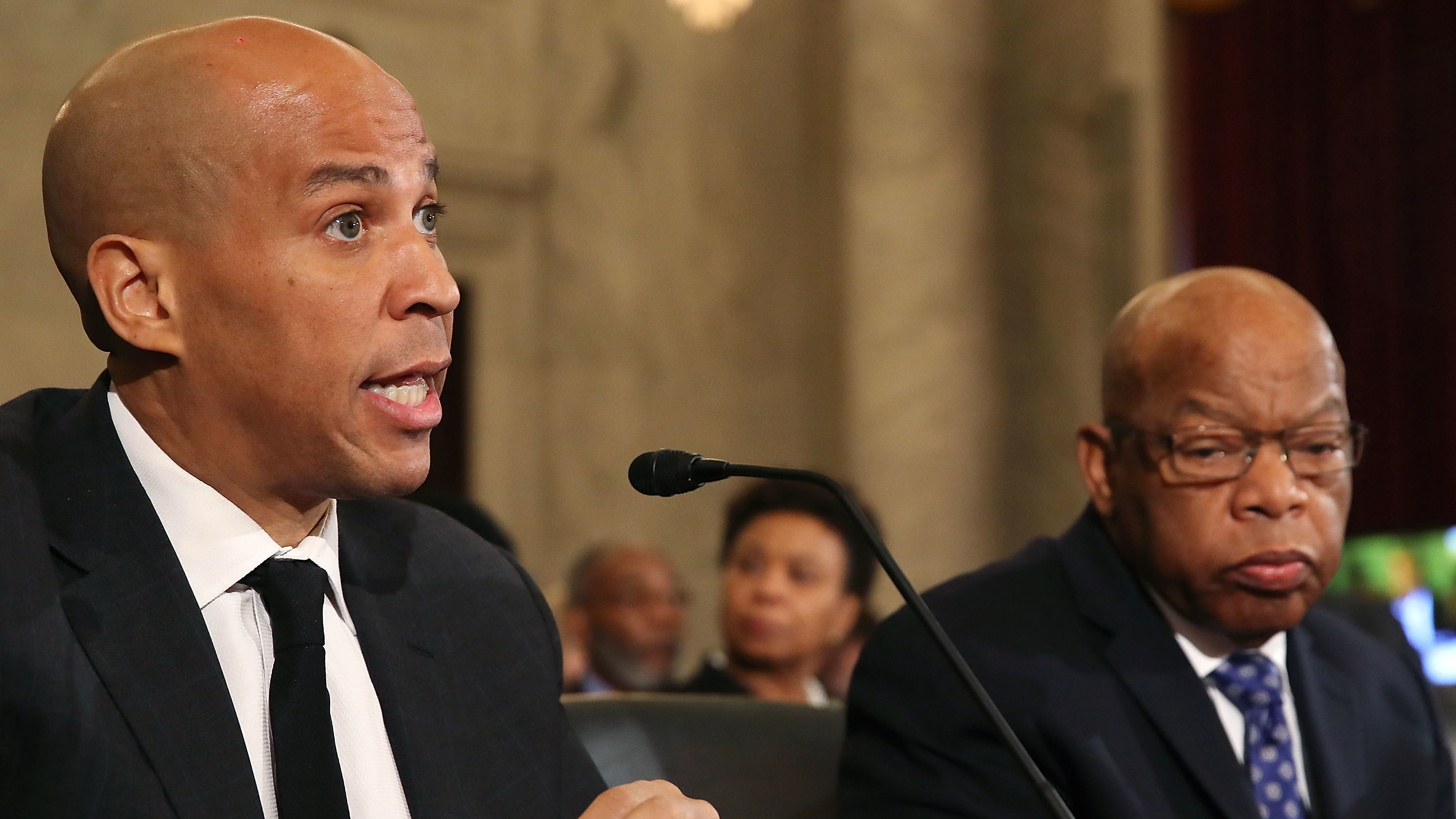 Sen. Cory Booker (left) reads a statement speaking out against Attorney General nominee Jeff Sessions during a Senate Judiciary Committee hearing on Wednesday. Sitting with Booker is Rep. John Lewis. (Getty Images)