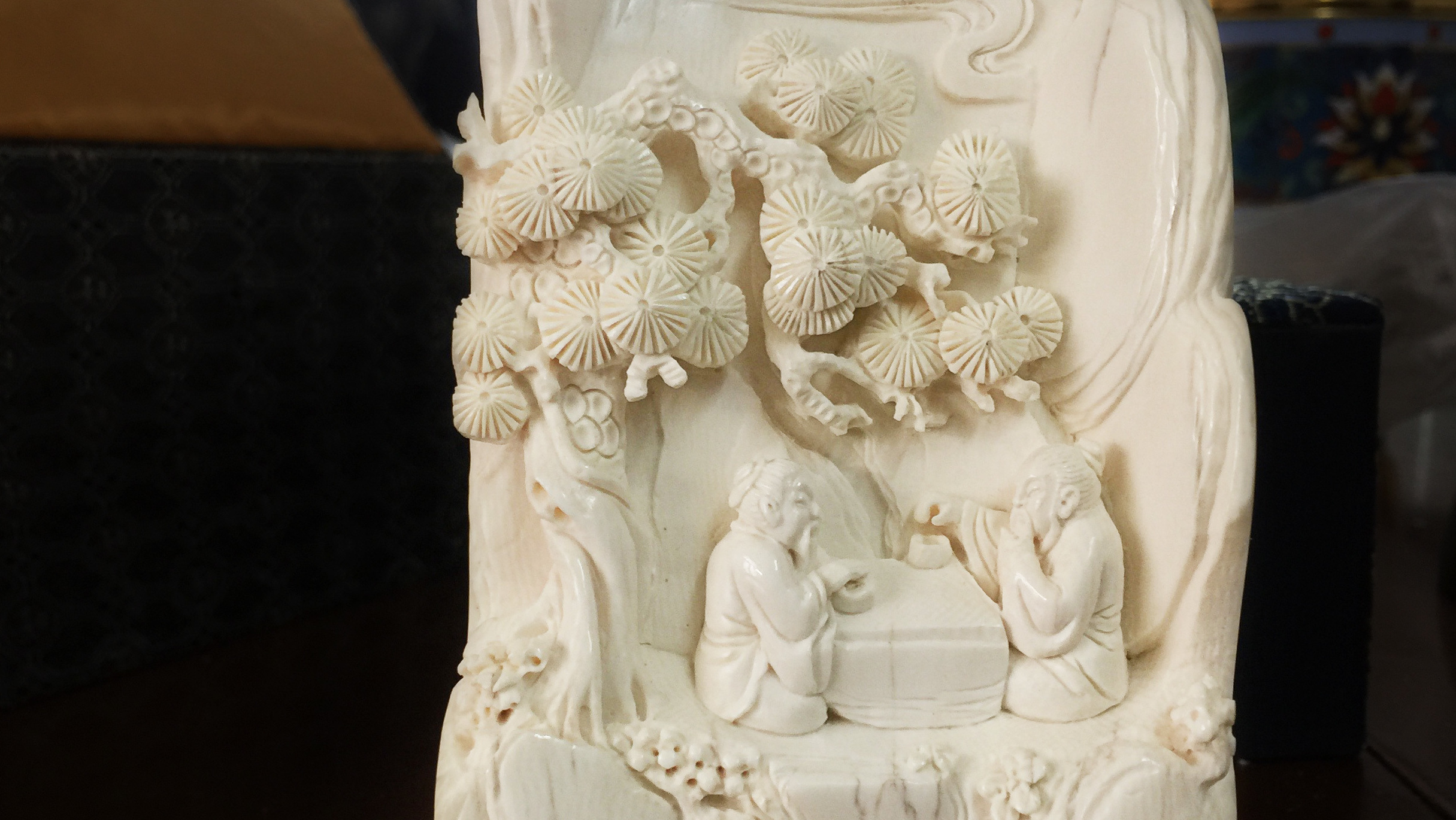 An ivory carving made from a piece of scrap by an apprentice of carver Li Chunke shows two men playing Go under a pine tree. (NPR)