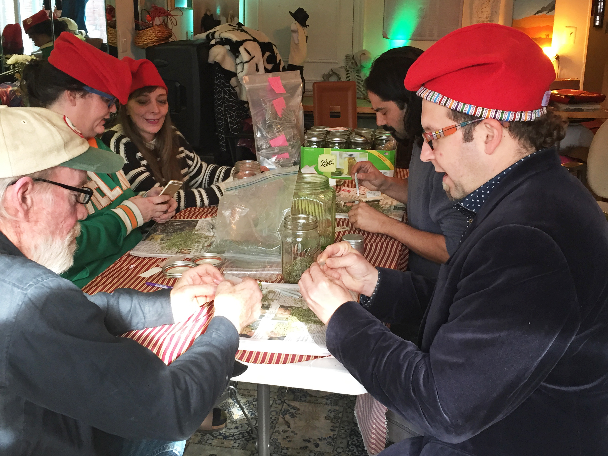 Adam Eidinger (at right, in hat), a leader of DC Cannabis Coalition, and other volunteers roll marijuana joints they plan to hand out for free on Inauguration Day. (NPR)