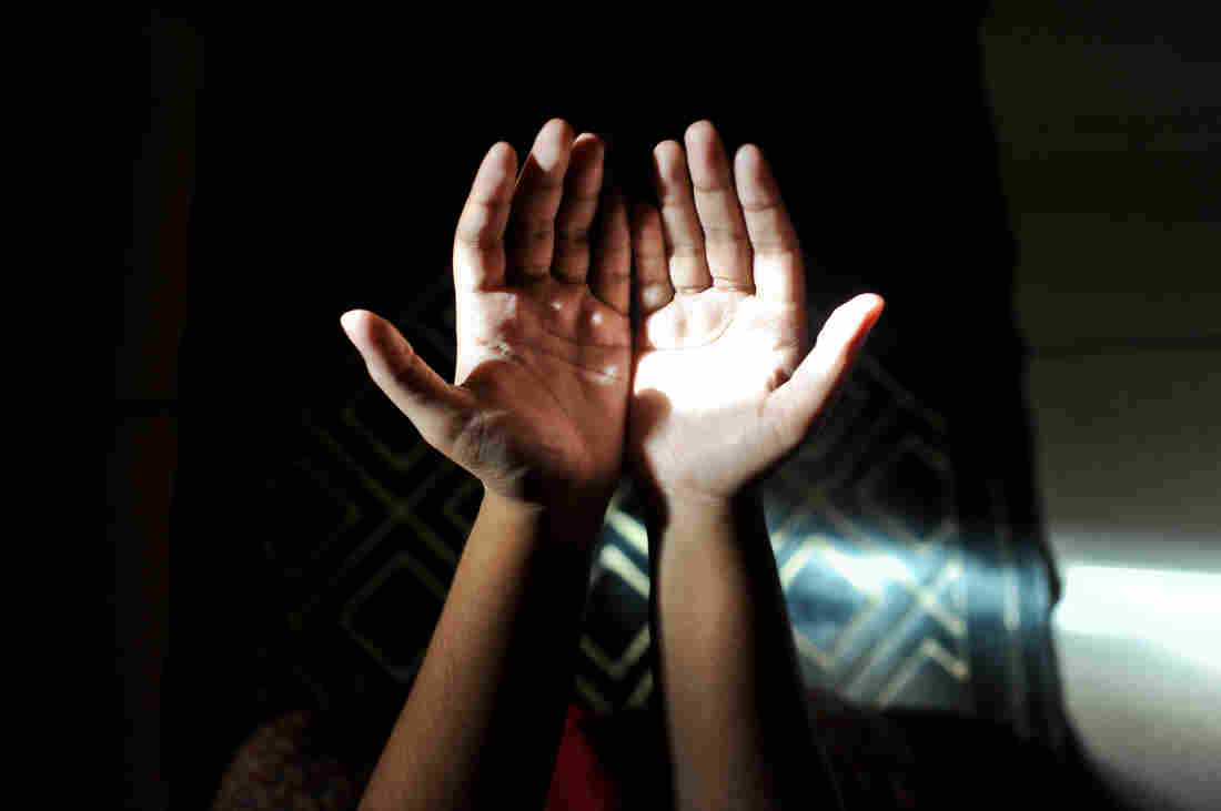 A Muslim woman prays in her home.