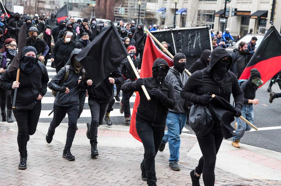Protestors run through the street before the inauguration of Donald Trump. (Zach Gibson/AFP/Getty Images)