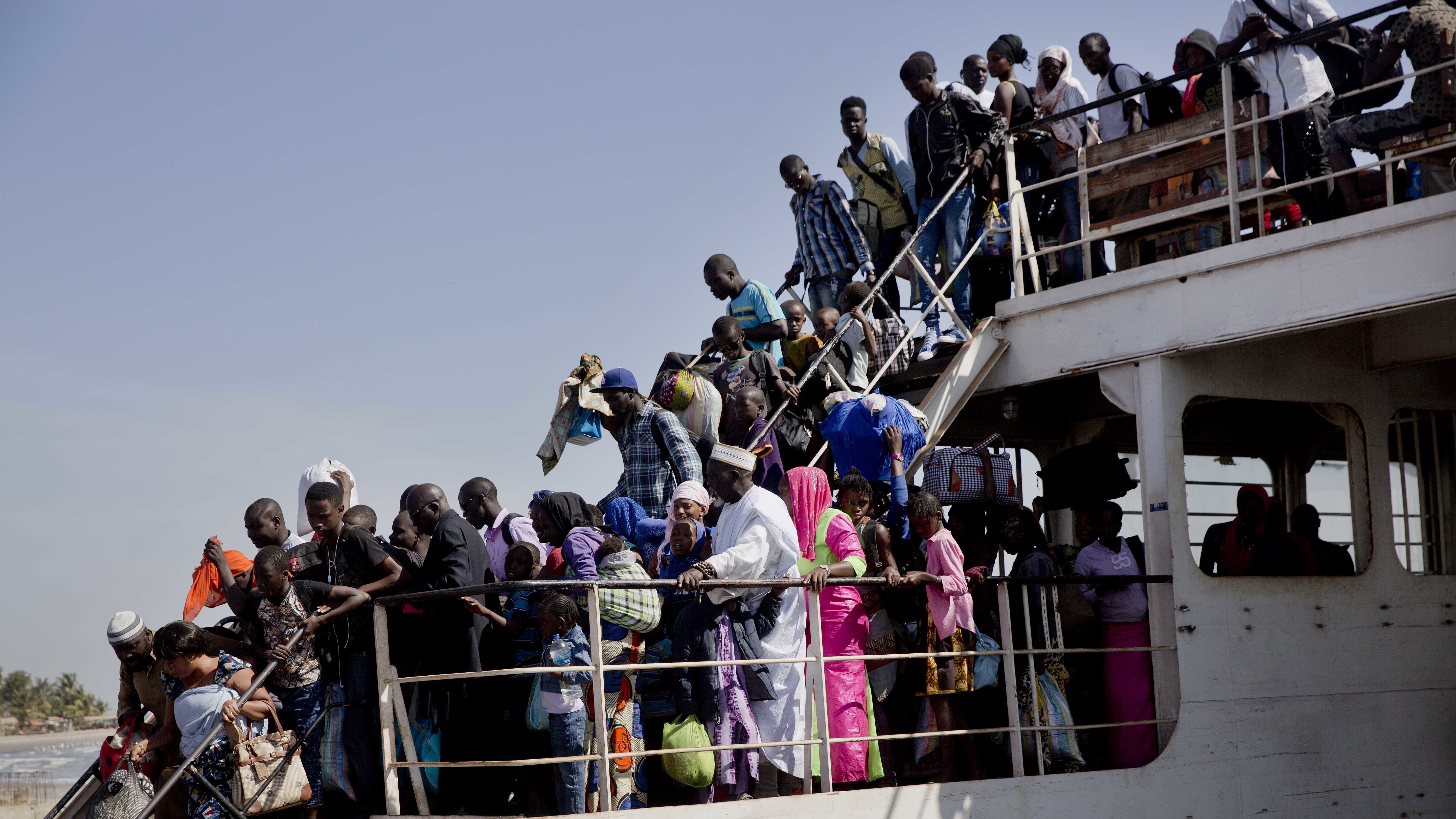 A ferry carrying people who fled Gambia arrives at the port in Banjul, Gambia, on Sunday.