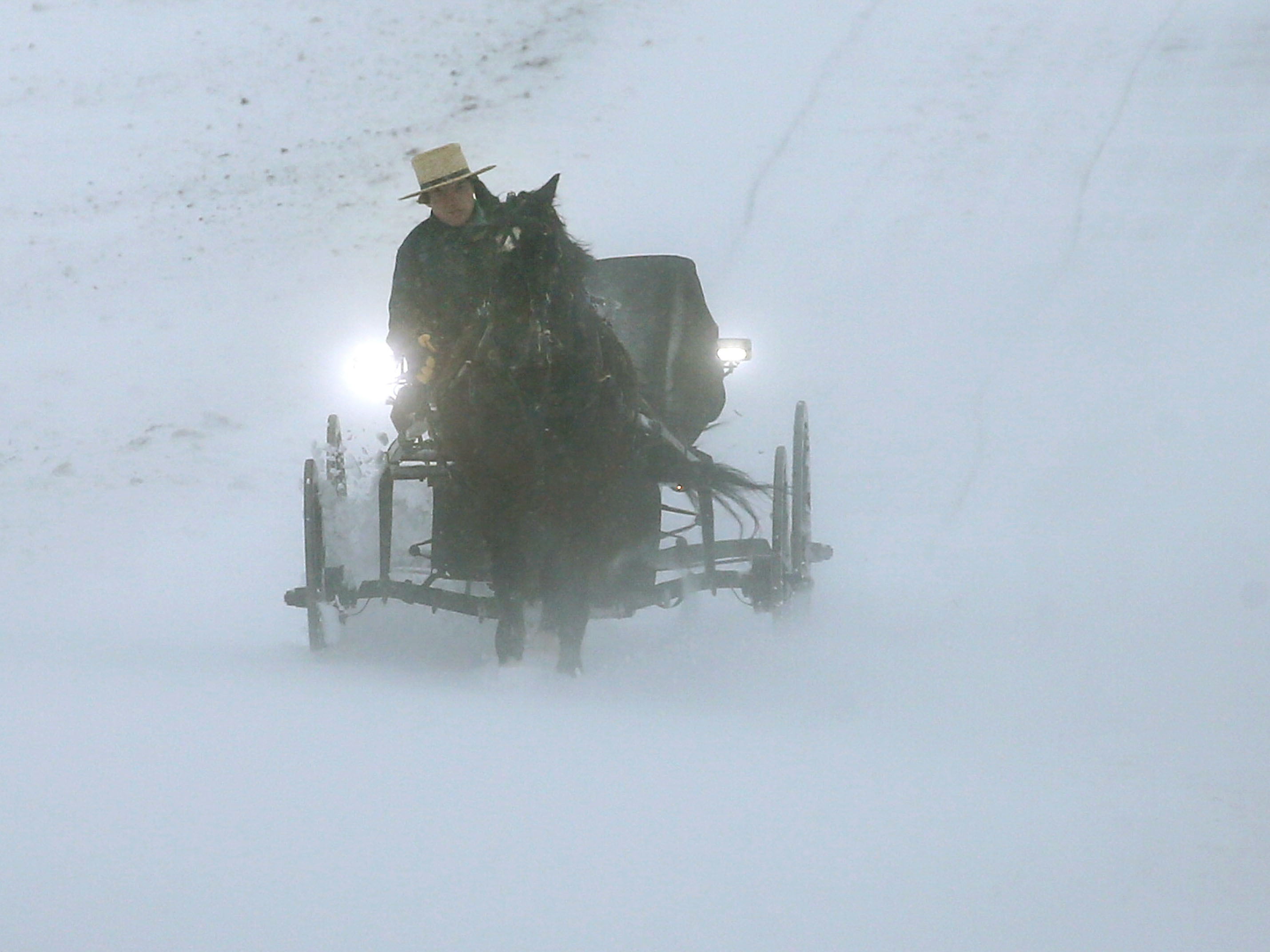 An Amish man drives his buggy through heavy snow and wind on Monday in Mechanicsville, Md. (Mark Wilson/Getty Images)