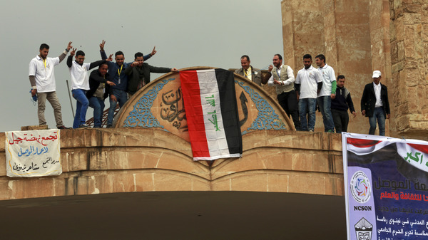 Students at Mosul University place the Iraqi national flag at the entrance on Sunday after it was liberated from Islamic State militants. The Iraqi military, supported by the U.S., has retaken the eastern part of the city. ISIS still holds the western part of Mosul, its last major stronghold in Iraq.