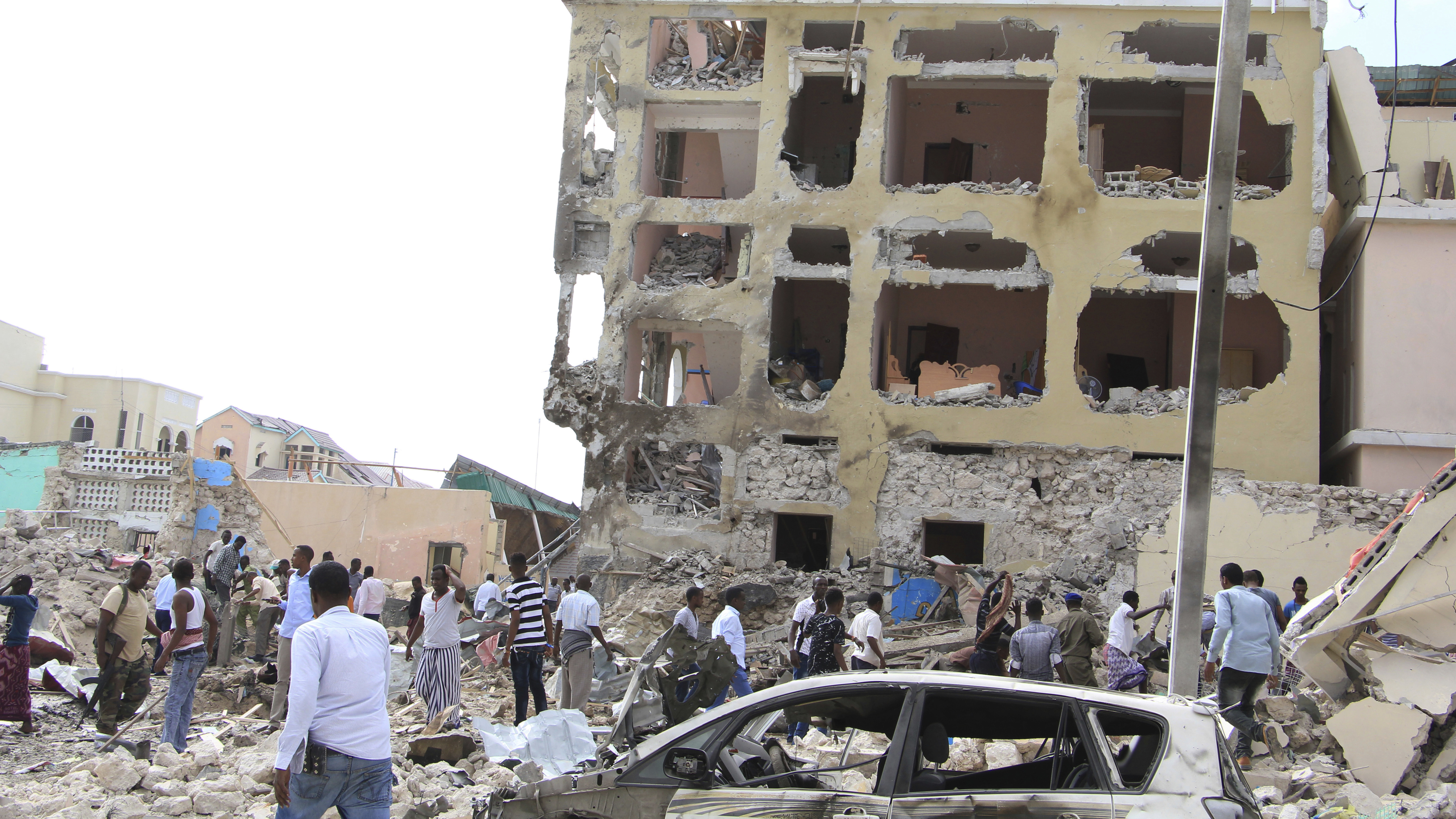 A crowd gathers near the Dayah Hotel after it was heavily damaged by bomb blasts on Wednesday in Mogadishu, Somalia.