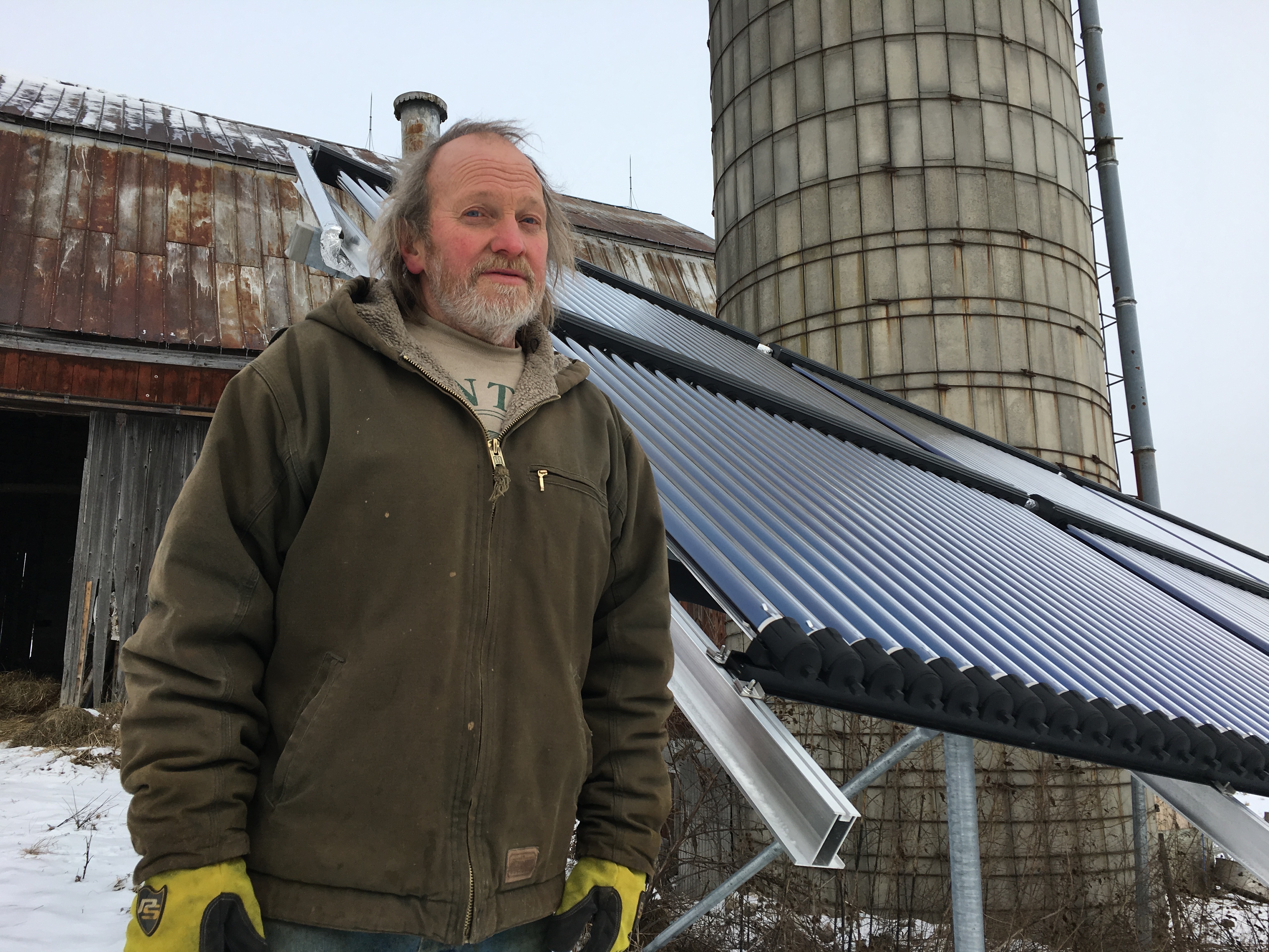 Rick Moore, a dairy farmer in Canton, N.Y., has a solar thermal array to heat water he uses to spray down milking equipment. (North Country Public Radio)