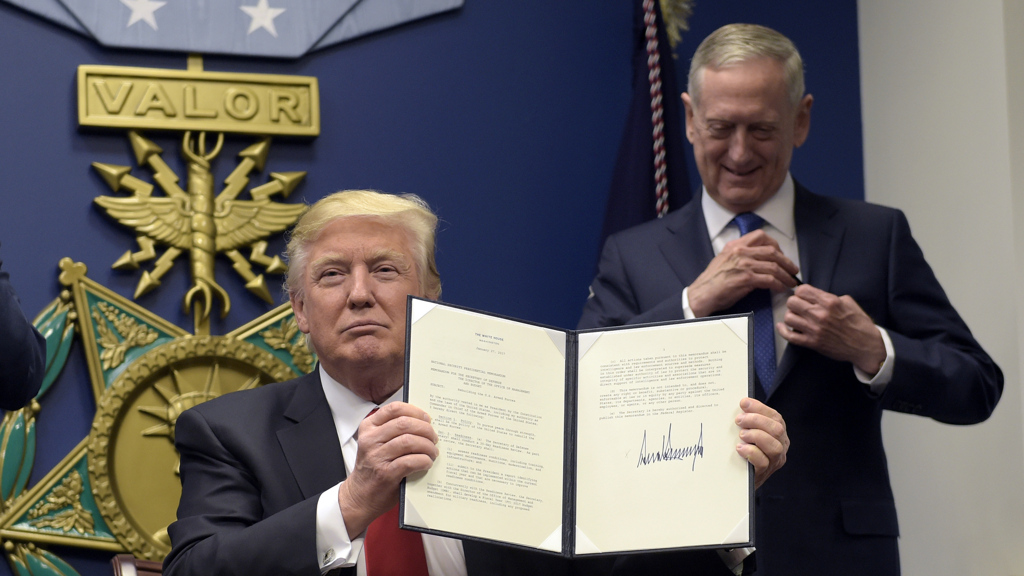 President Trump, with Defense Secretary James Mattis, shows his signature on an executive action to rebuild the military, during an event at the Pentagon on Friday.