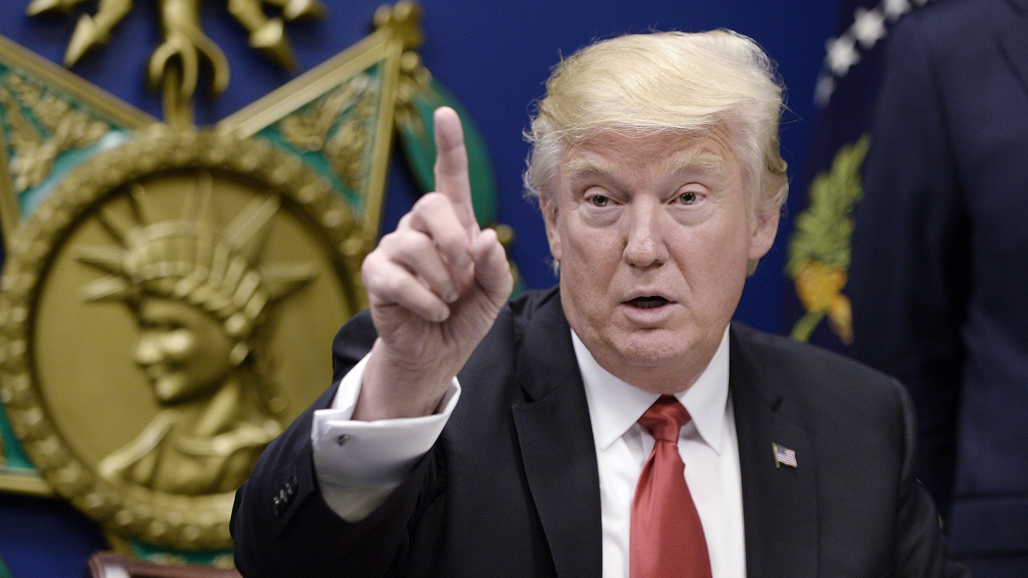 President Donald Trump signs executive orders in the Hall of Heroes at the Department of Defense on Friday in Arlington, Va.