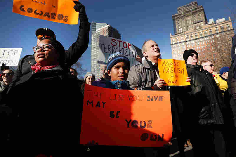 People attend an afternoon rally in New York City's Battery Park to protest President Donald Trump's immigration policies.