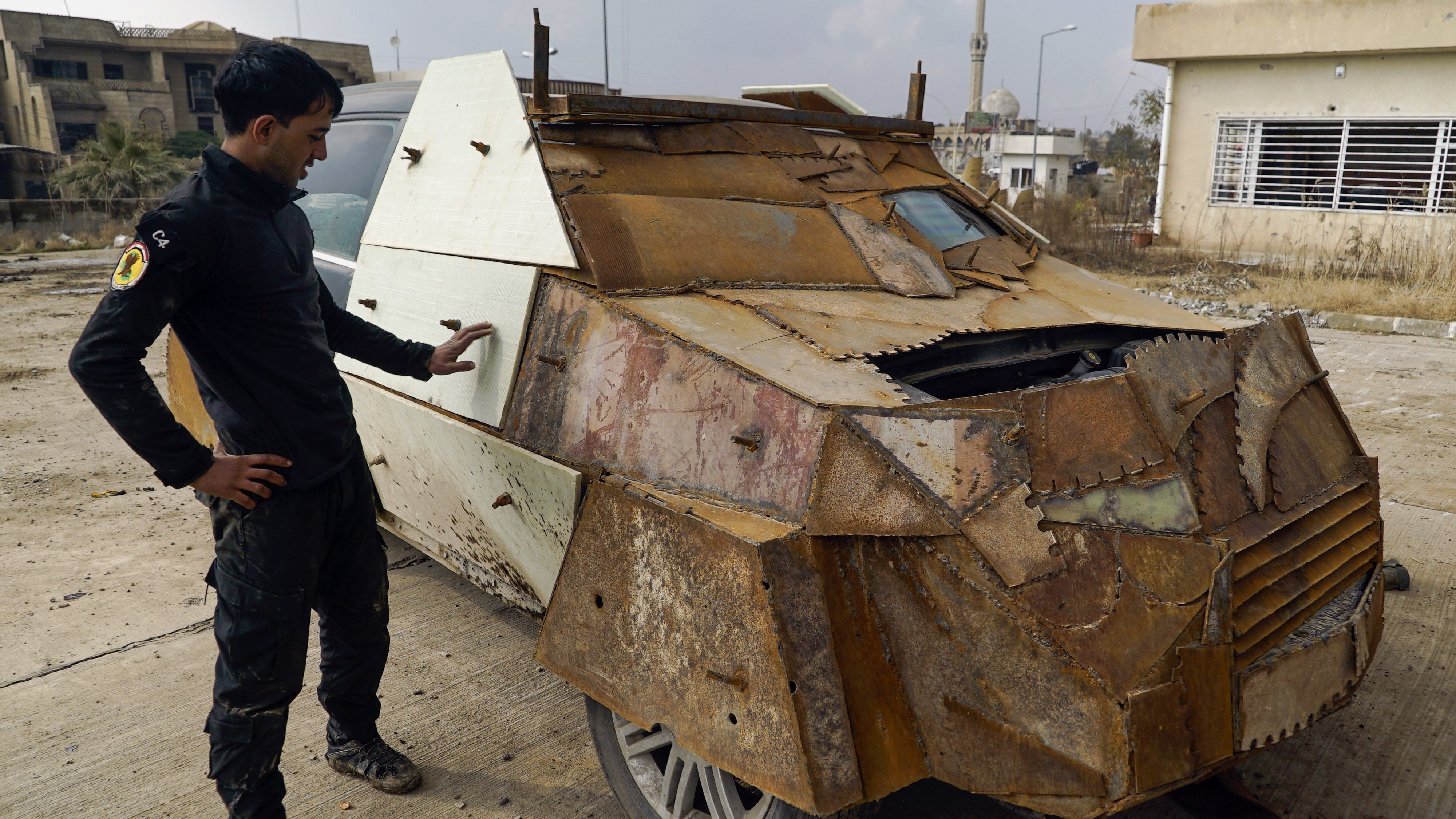 An Iraqi soldier on Sunday stands near a makeshift armored car left behind by the Islamic State when they were driven out of the eastern side of Mosul. President Trump has ordered the U.S. military to draw up a new plan for the fight against ISIS.