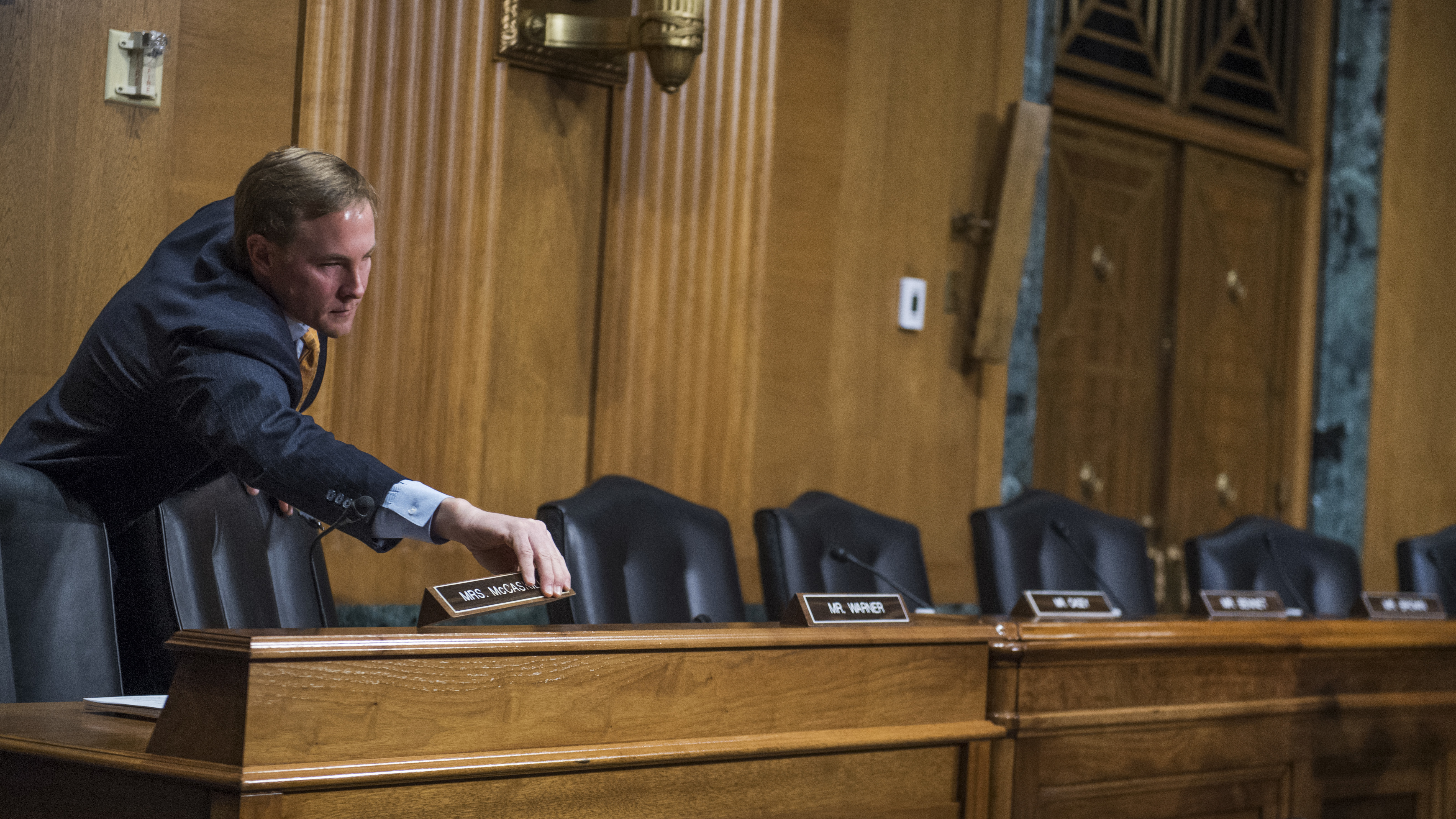 Chris Campbell, Republican staff director for the Senate Finance Committee chairman, sets nameplates out for Democratic senators who boycotted the committee vote on Rep. Tom Price, R-Ga., nominee for HHS secretary and Steve Mnuchin, nominee for Treasury secretary. (CQ-Roll Call Inc.)
