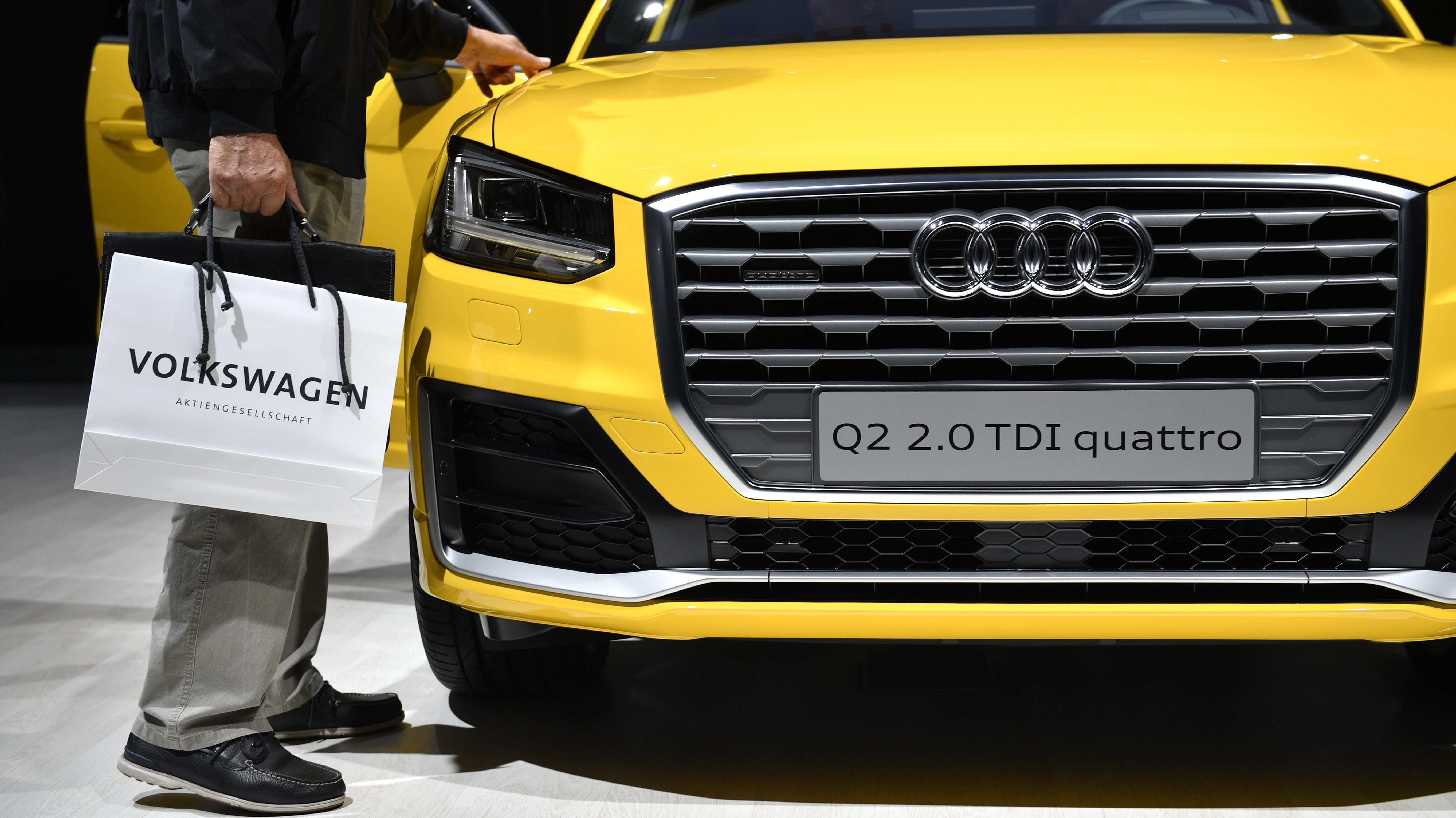 Owners of vehicles with larger VW diesel engines that have emissions-cheating software could get their cars fixed or bought back, the company says. Here, a man walks by an Audi diesel at company meetings last summer. (Getty Images)