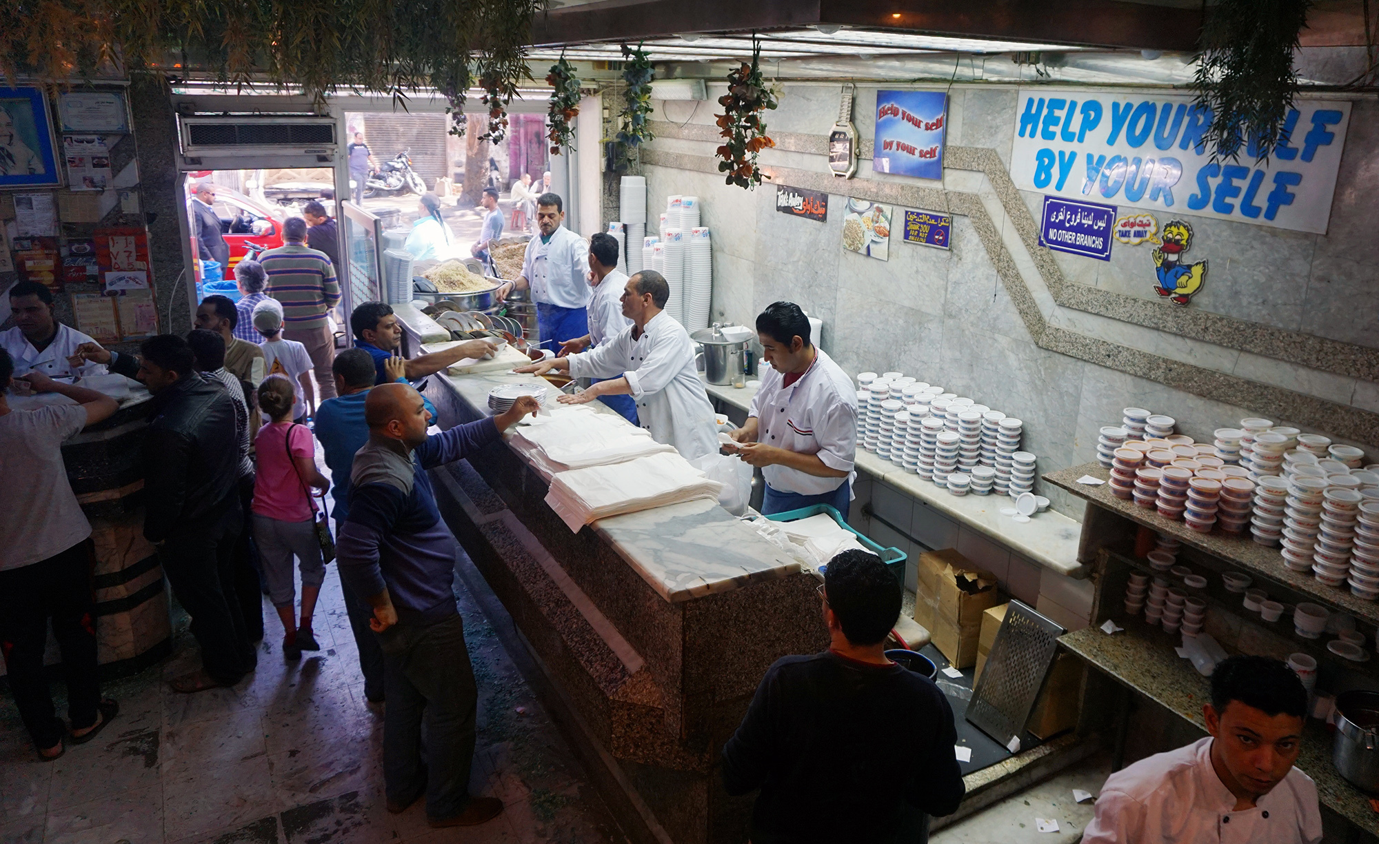 The assembly line set-up at Koshary Abou Tarek helps staff to keep up with the flood of orders at lunchtime. (Amy E. Robertson for NPR)
