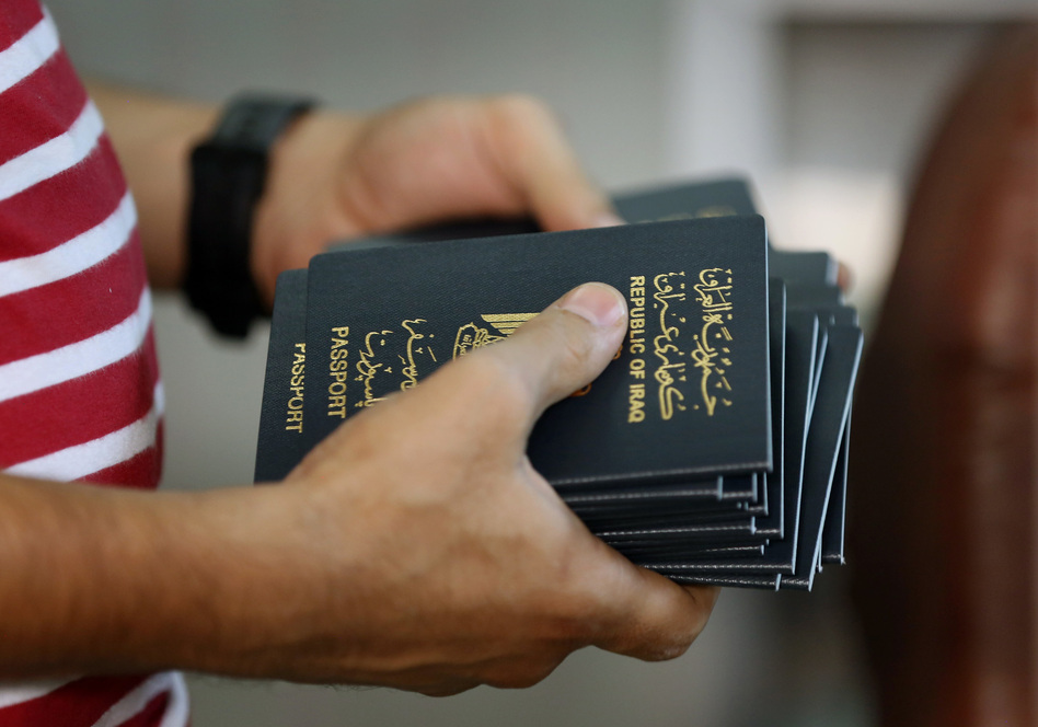 An employee delivers new passports at the main Baghdad Passport office in the Iraqi capital in 2015. (Hadi Mizban/AP)