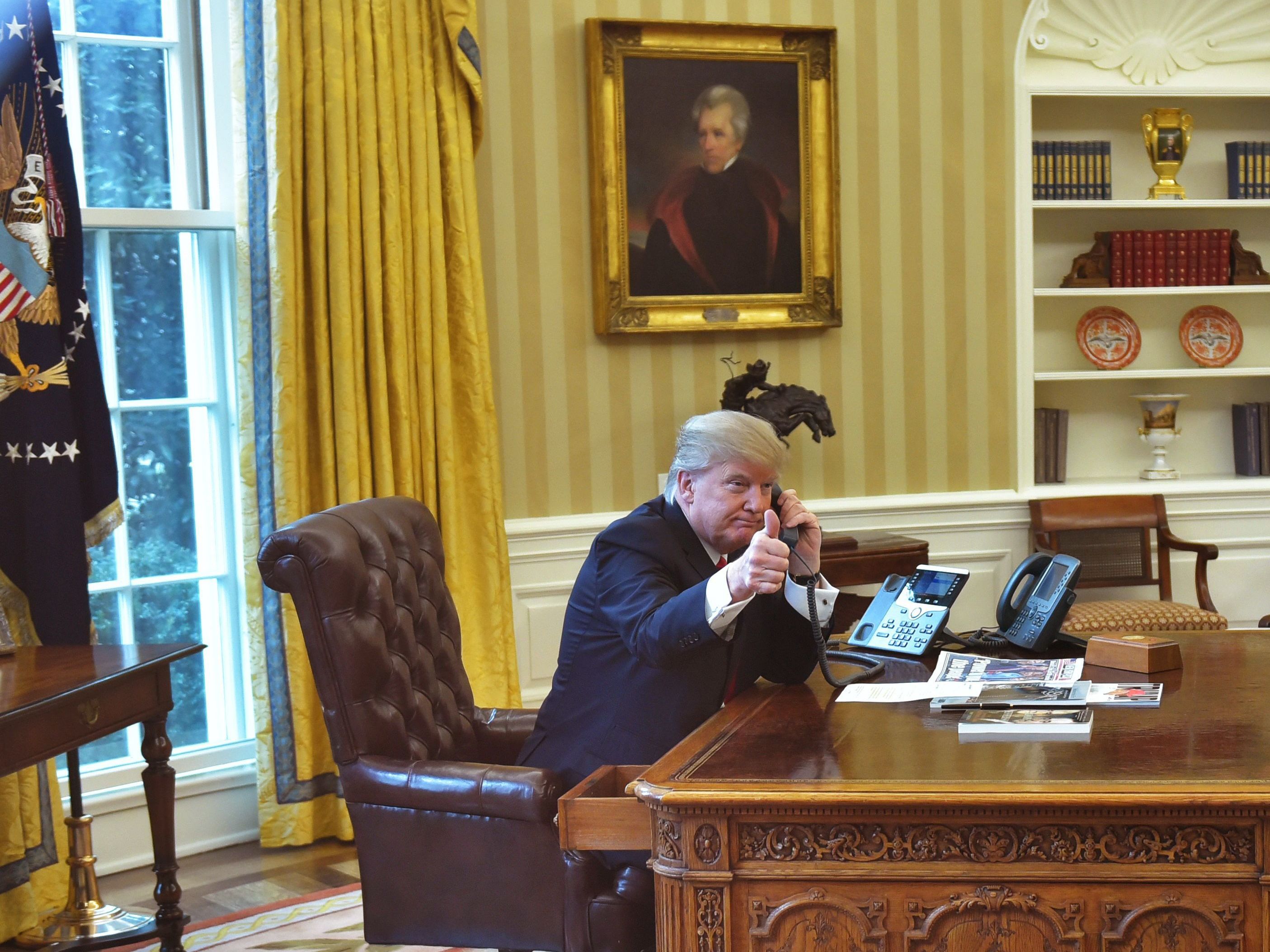 President Trump gives a thumbs up as he speaks on the phone in the Oval Office on Jan. 29. (AFP/Getty Images)