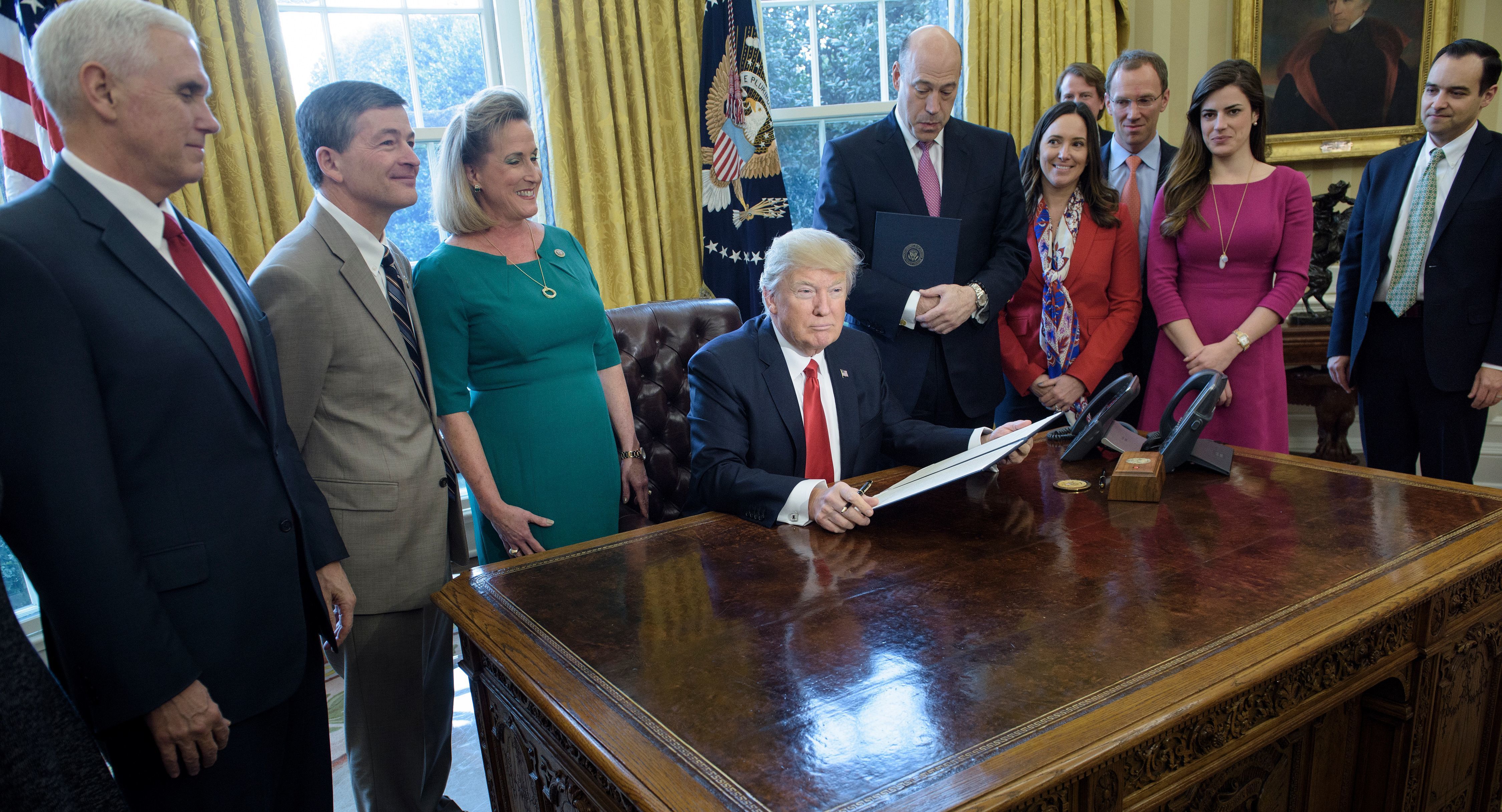 President Trump waits to sign an executive action directing the Treasury secretary to review the Dodd-Frank financial oversight law in the Oval Office on Friday. (AFP/Getty Images)