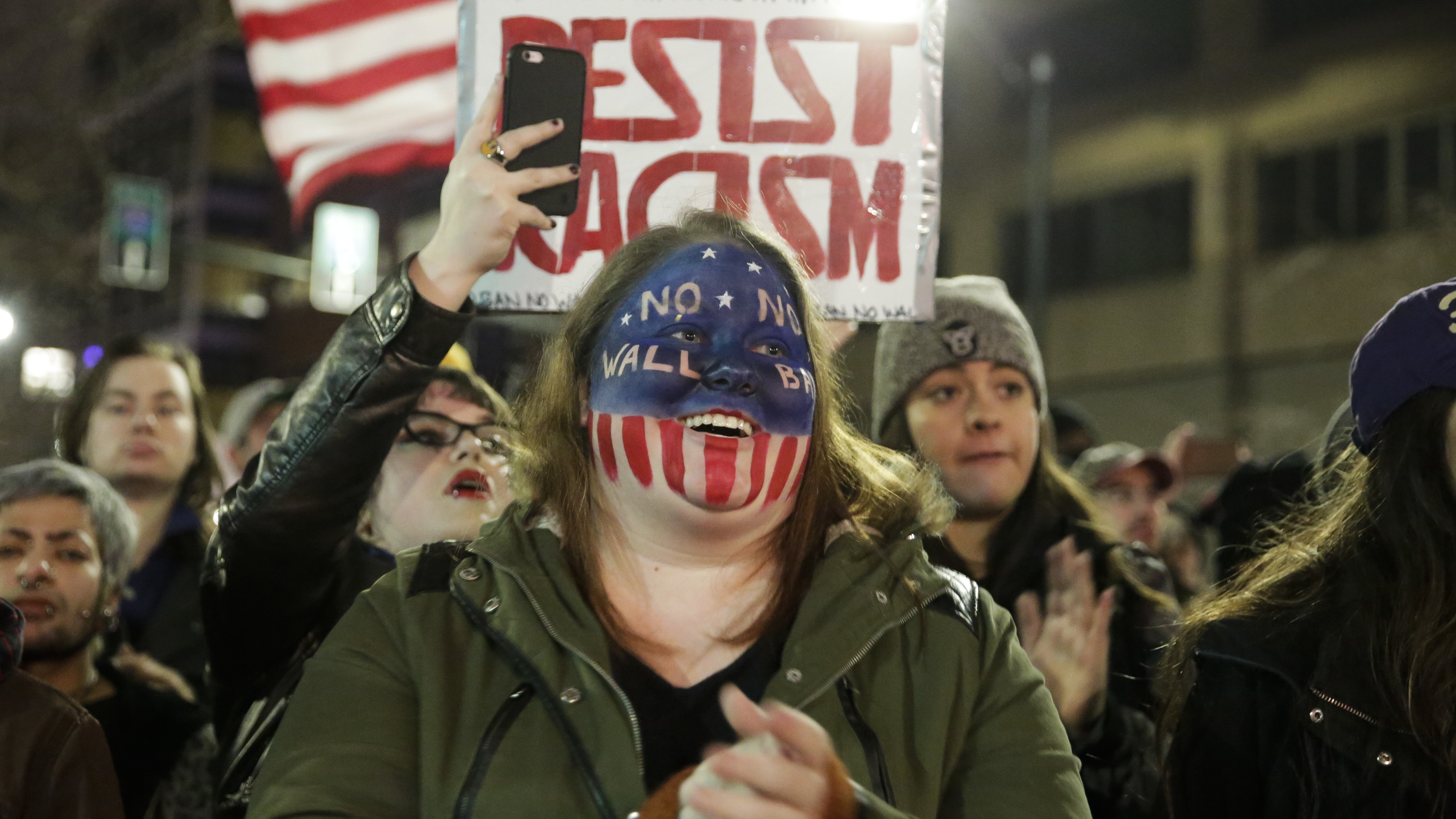 A woman with &quot;No Wall, No Ban&quot; painted on her face was among the people marching in support of immigrants and refugees in Seattle on Jan. 29. (AFP/Getty Images)