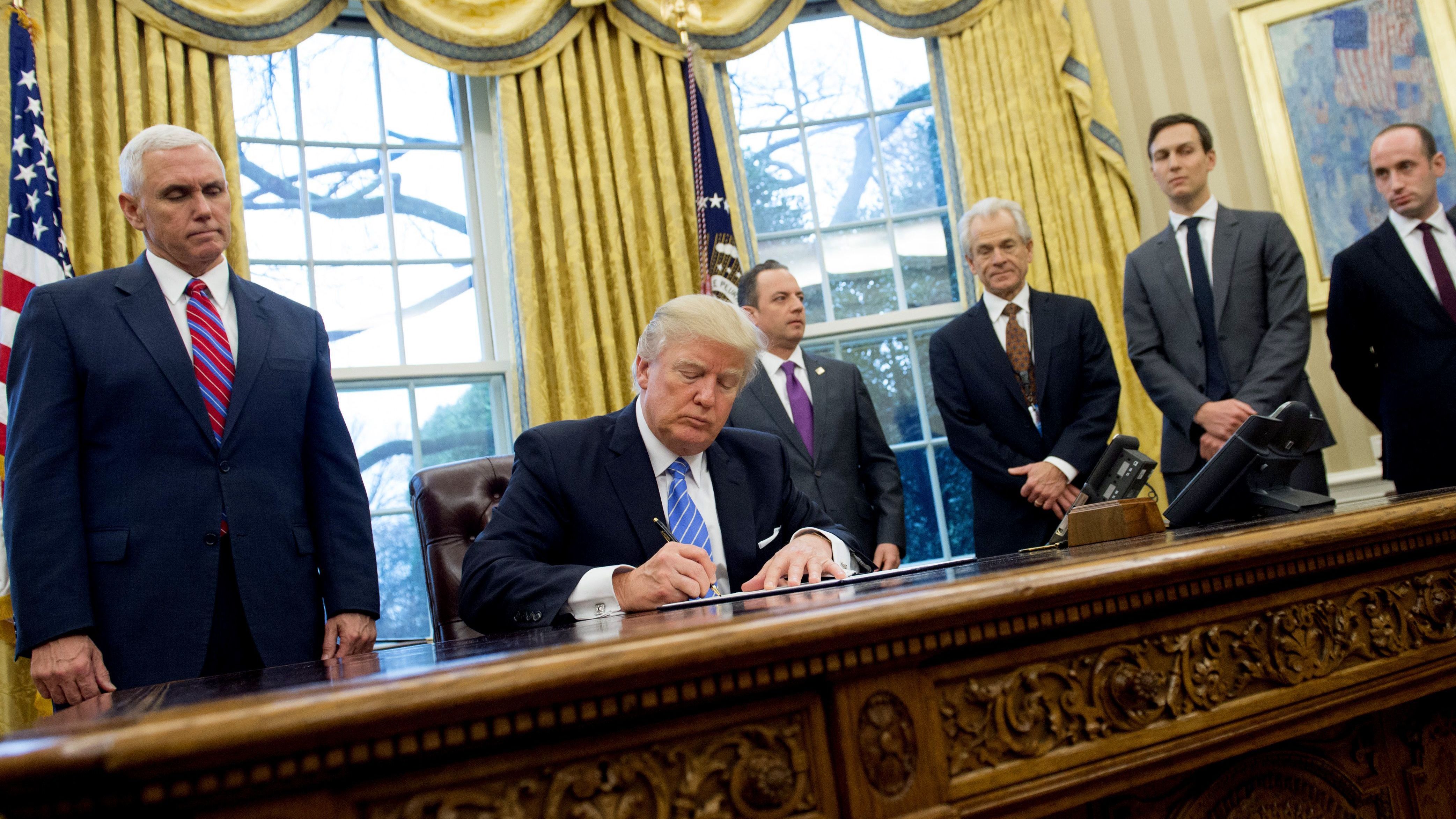President Trump signs an executive order alongside Vice President Pence administration officials. One of the documents Trump signed that day was a memorandum reinstating the &quot;Mexico City policy.&quot; (AFP/Getty Images)