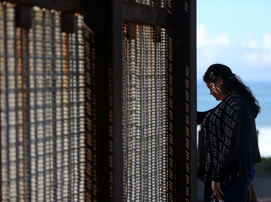 A visitor stands next to the U.S.-Mexico border fence at Friends of Friendship Park on Feb. 4 in San Ysidro, Calif. (Justin Sullivan/Getty Images)
