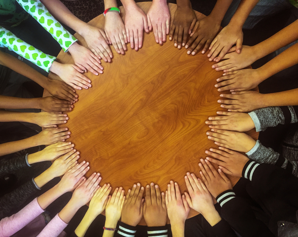Students' hands gather in a circle in Tanya Streicher's class at Gilpin Montessori School in Denver. (Courtesy of Tanya Streicher)