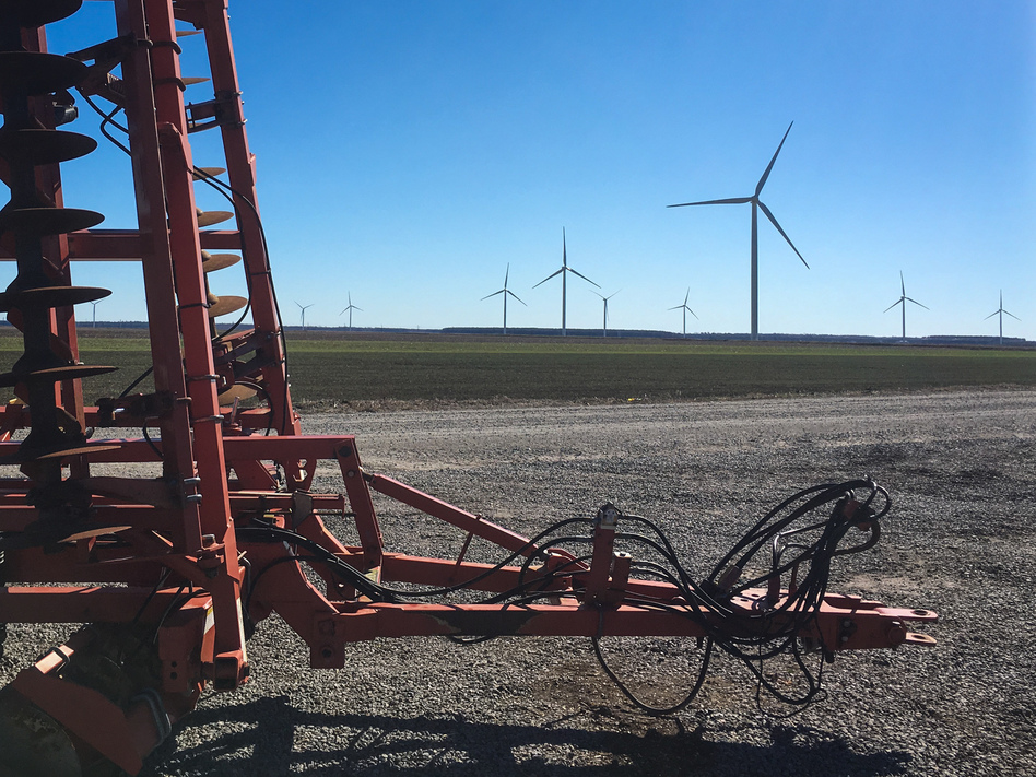 Wind turbines and farm equipment now dot Horace Pritchard's land, where he raises corn, soybeans, and other crops. He also receives payments for hosting nine of the more than 100 wind turbines now operating near Elizabeth City, N.C. (Sarah McCammon/NPR)