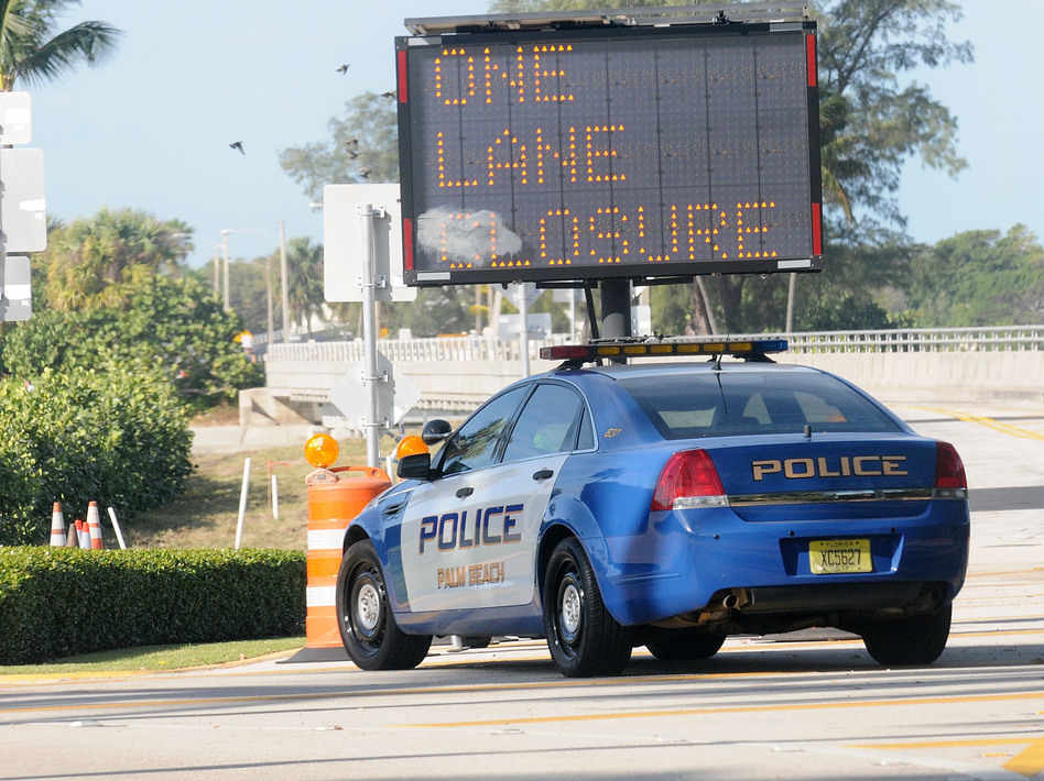 A Palm Beach Police car sits in front of a gate of the Mar-a-Lago Resort in November. During President Trump's frequent visits, the Secret Service shuts down a major thoroughfare, making it difficult to get anywhere in Palm Beach. (Gerardo Mora/Getty Images)