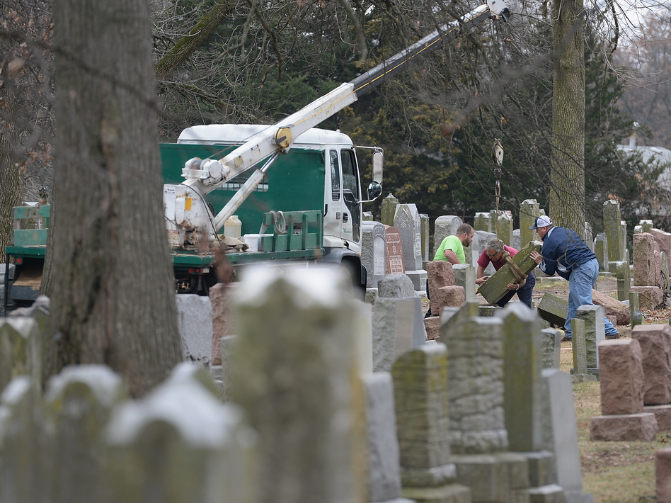 Volunteers from a local monument company help to reset vandalized headstones on Feb. 22 at Chesed Shel Emeth Cemetery in University City, Missouri, a St. Louis suburb. Since the beginning of the year, there has been a spike in incidents around the country, including bomb threats at Jewish community centers and reports of anti-Semitic graffiti. (Michael Thomas/Getty Images)