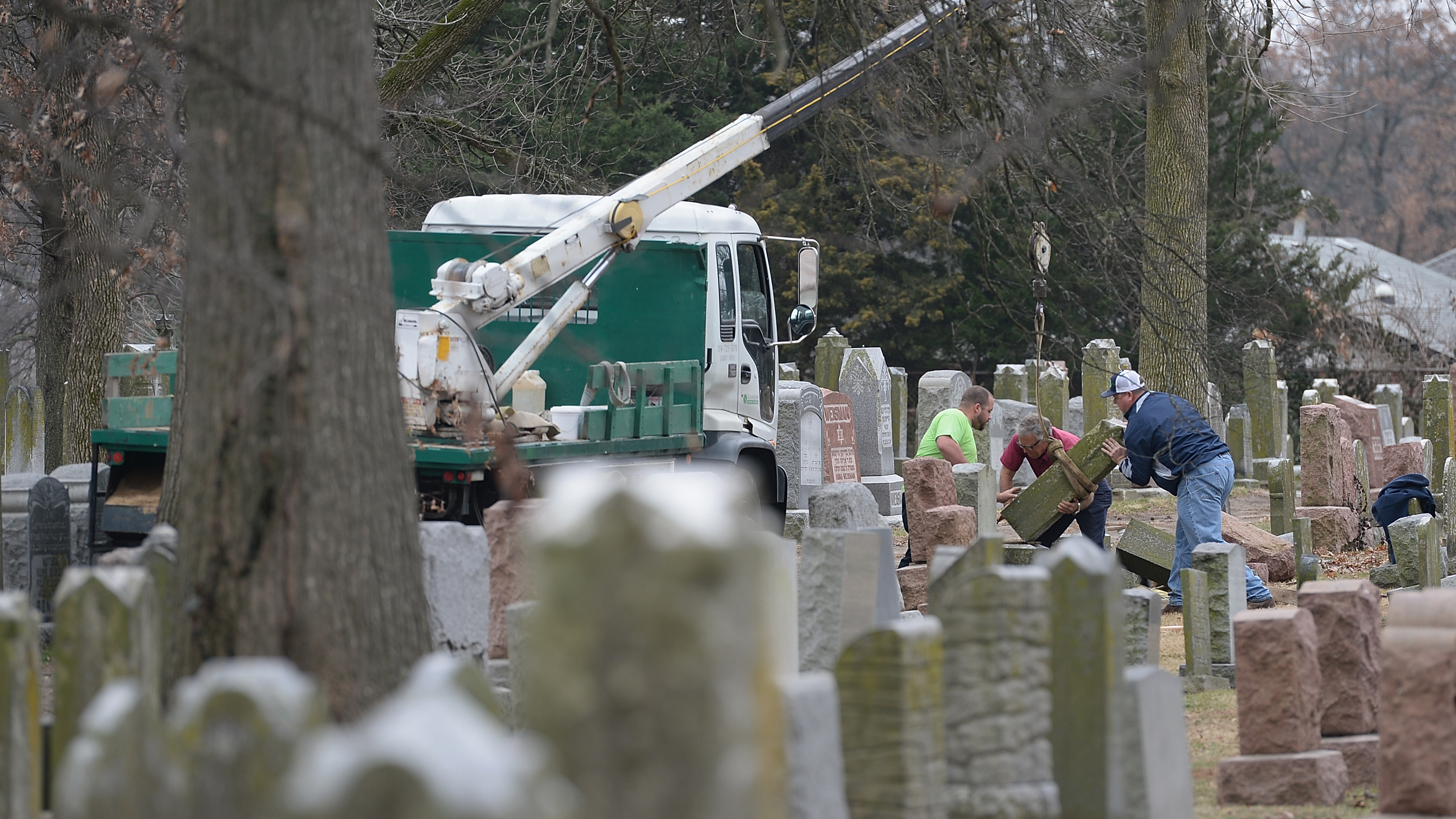 Volunteers from a local monument company help to reset vandalized headstones on Feb. 22 at Chesed Shel Emeth Cemetery in University City, Missouri, a St. Louis suburb. Since the beginning of the year, there has been a spike in incidents around the country, including bomb threats at Jewish community centers and reports of anti-Semitic graffiti.