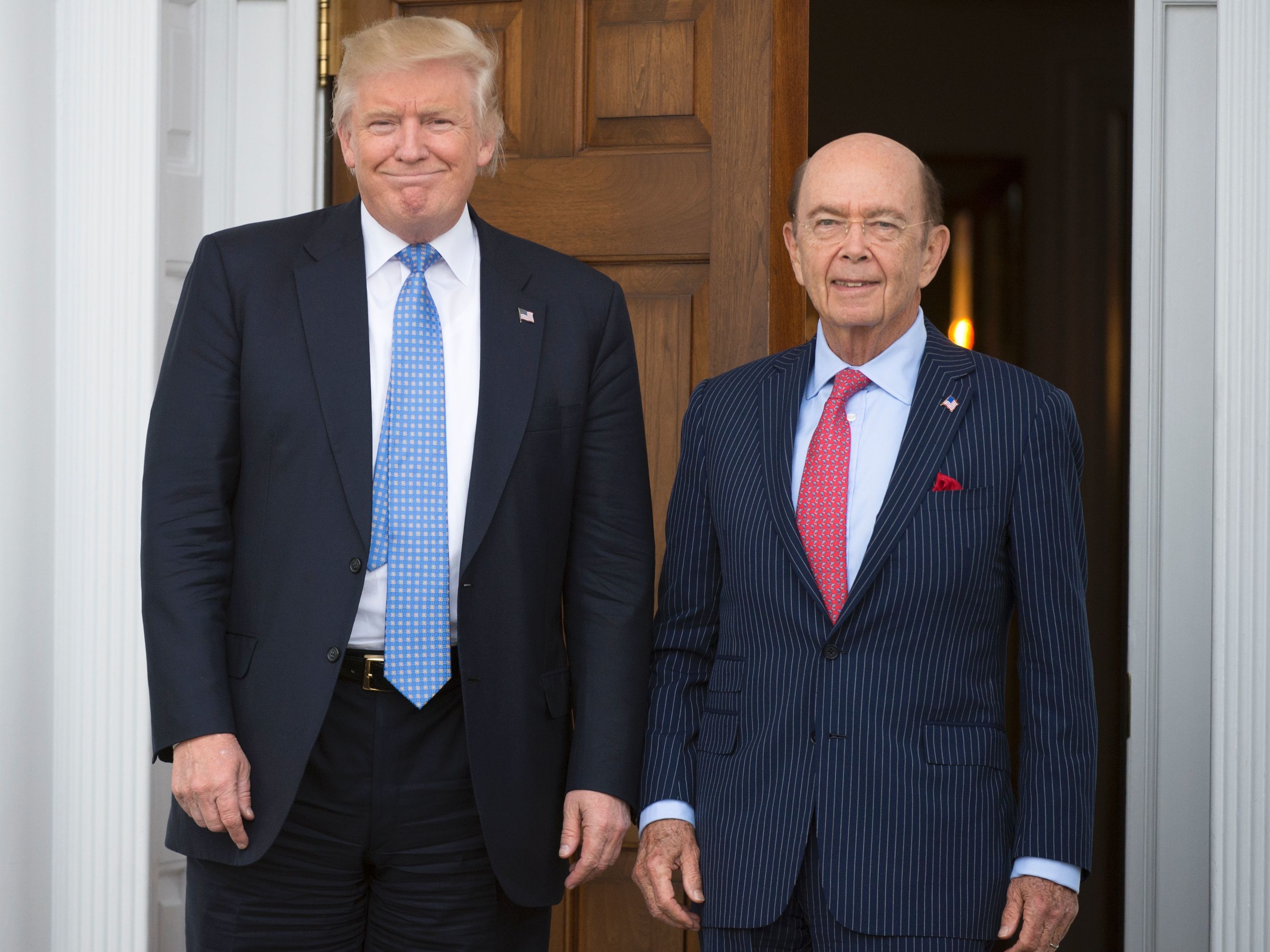 Federal conflict-of-interest laws require officials like commerce secretary nominee Wilbur Ross (right) to divest holdings, but President Trump is not covered by those requirements. (AFP/Getty Images)