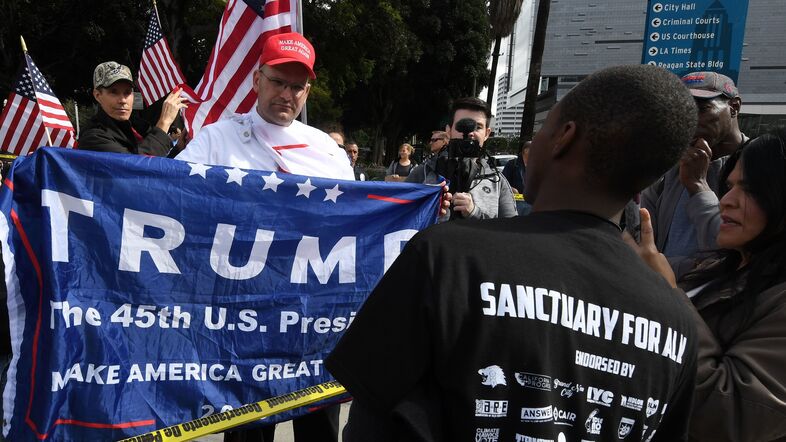 Pro-Trump supporters, left, argue with demonstrators after a Feb. 18 march in Los Angeles to protest the president's immigration policies. Sociologists say President Trump's actions and rhetoric are politically energizing both conservatives and liberals. (Mark Ralston/AFP/Getty Images)